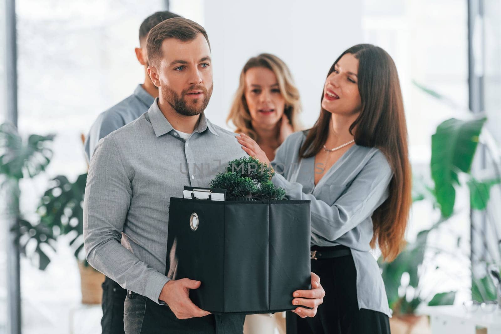 Man holding package. Group of business people that working on the project in the office.