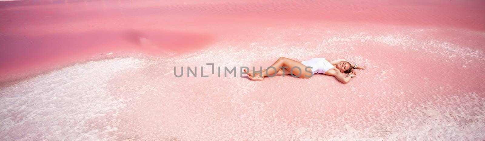 Woman in a pink salt lake banner . She lies in a white bathing suit. Wanderlust photo for memory by Matiunina