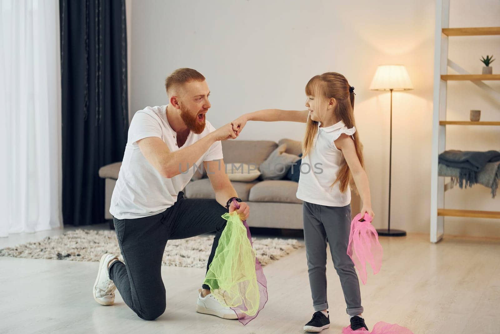 Having fun. Father with his little daughter is at home together.