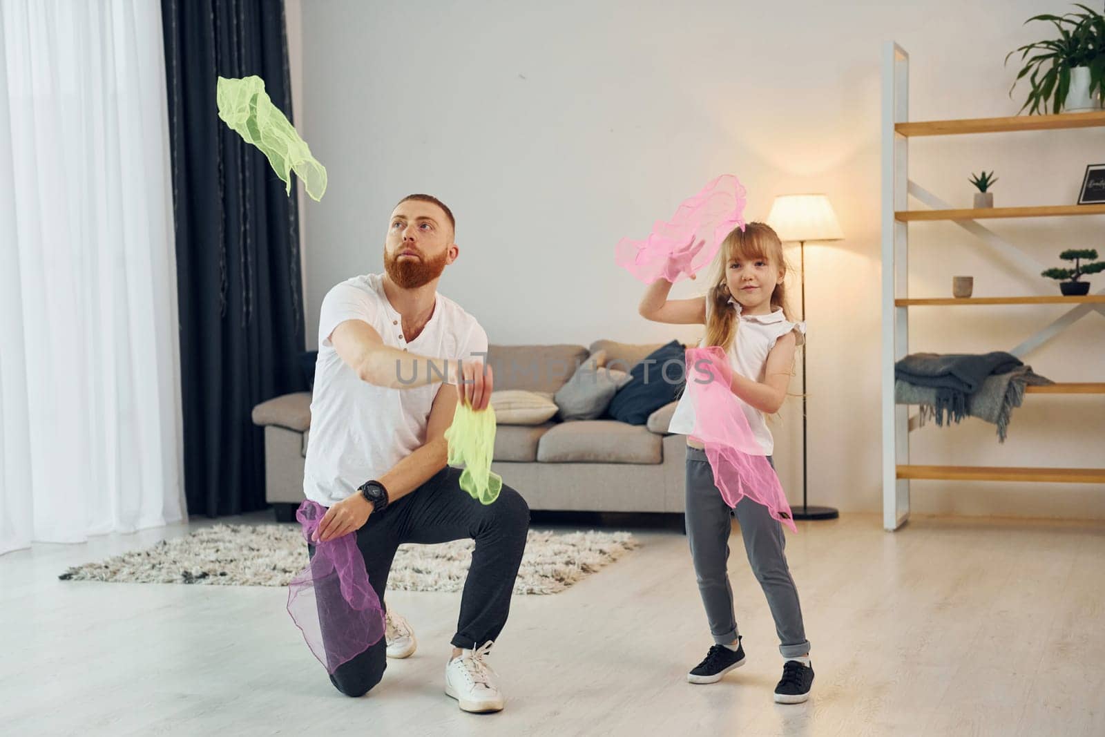 Holding cloth. Father with his little daughter is at home together.