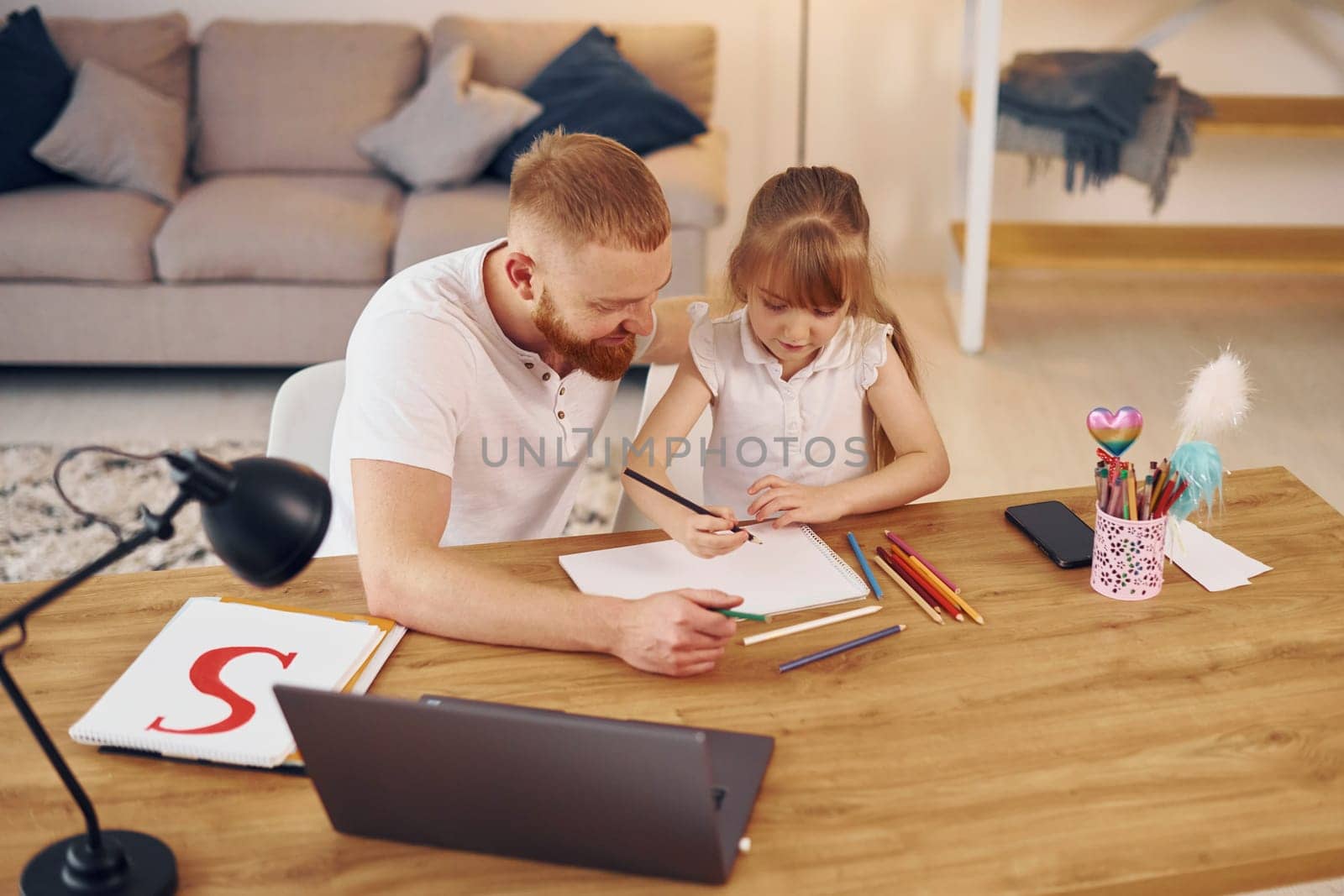 Online learning. Father with his little daughter is at home together.