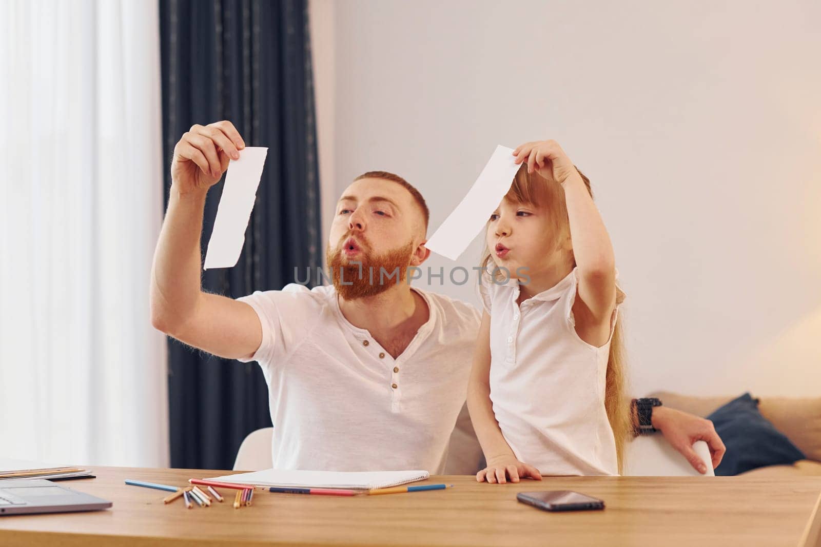 Father with his little daughter is at home together.