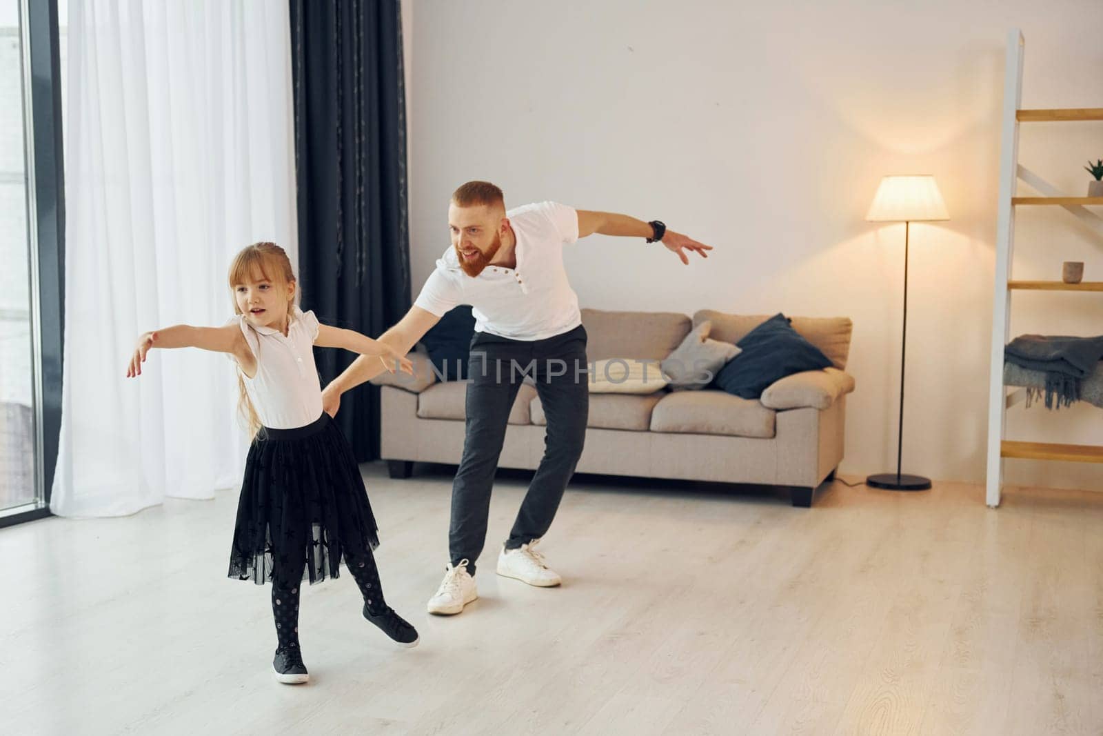 Learning to dance. Father with his little daughter is at home together.