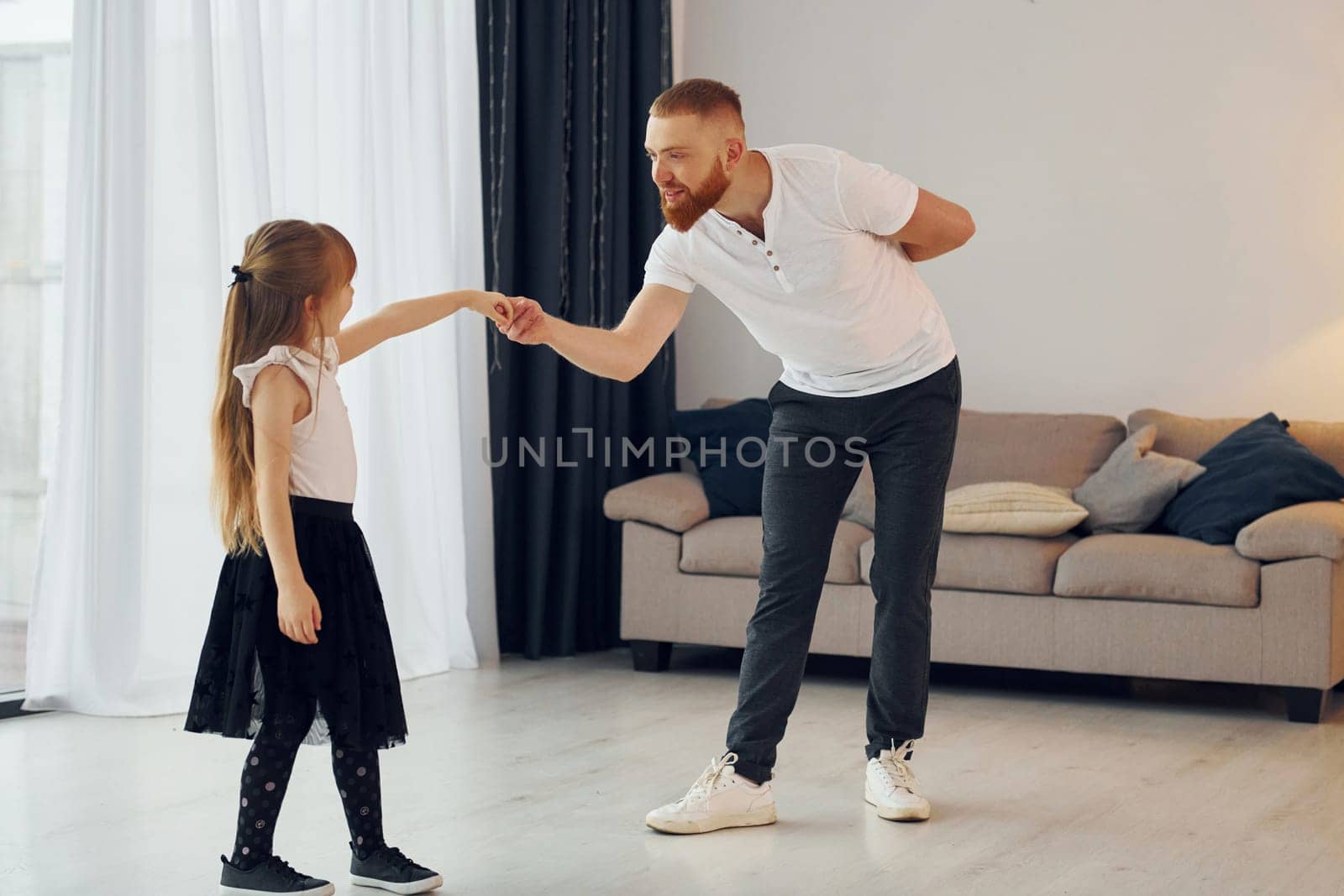 Learning to dance. Father with his little daughter is at home together.