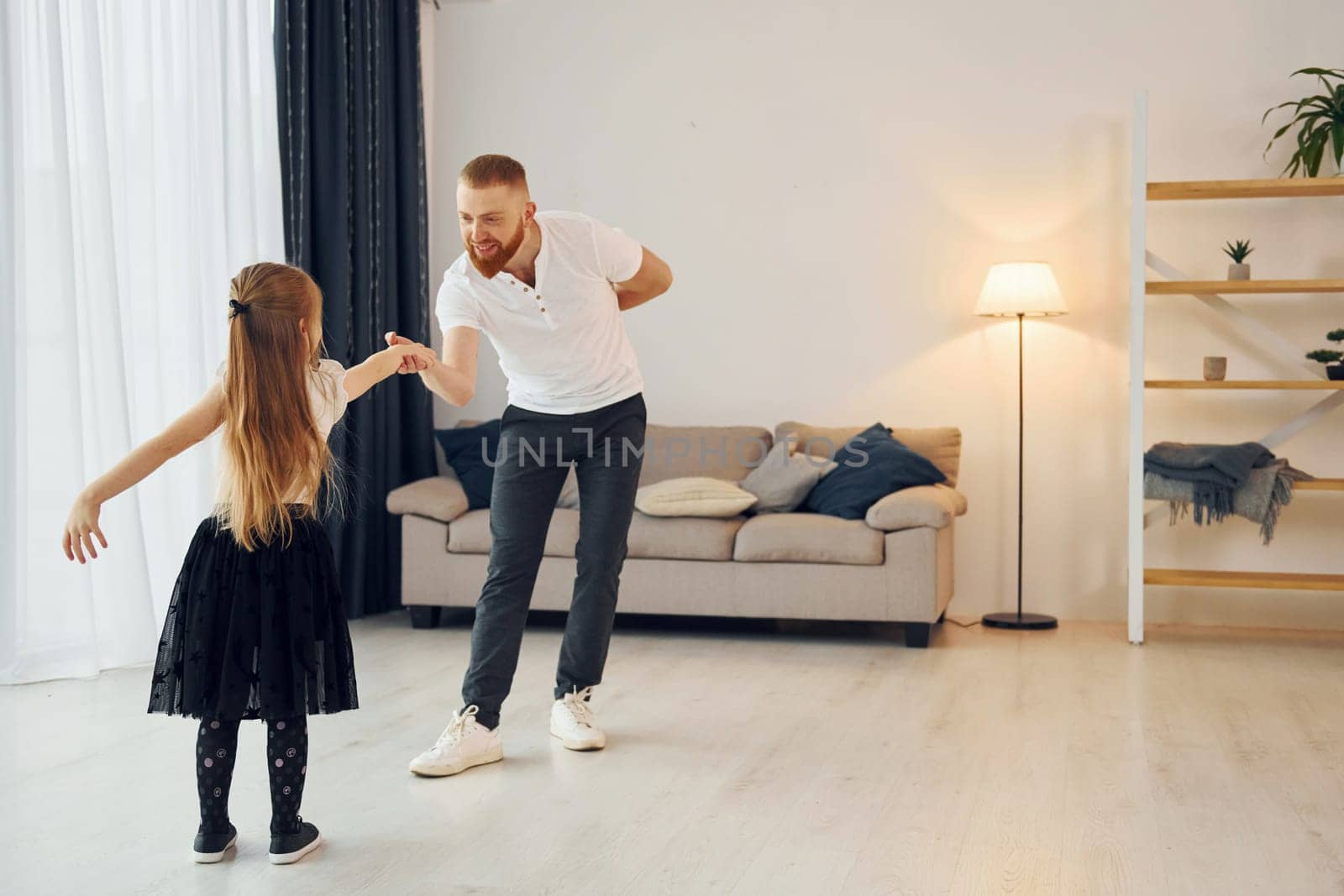 Learning to dance. Father with his little daughter is at home together.