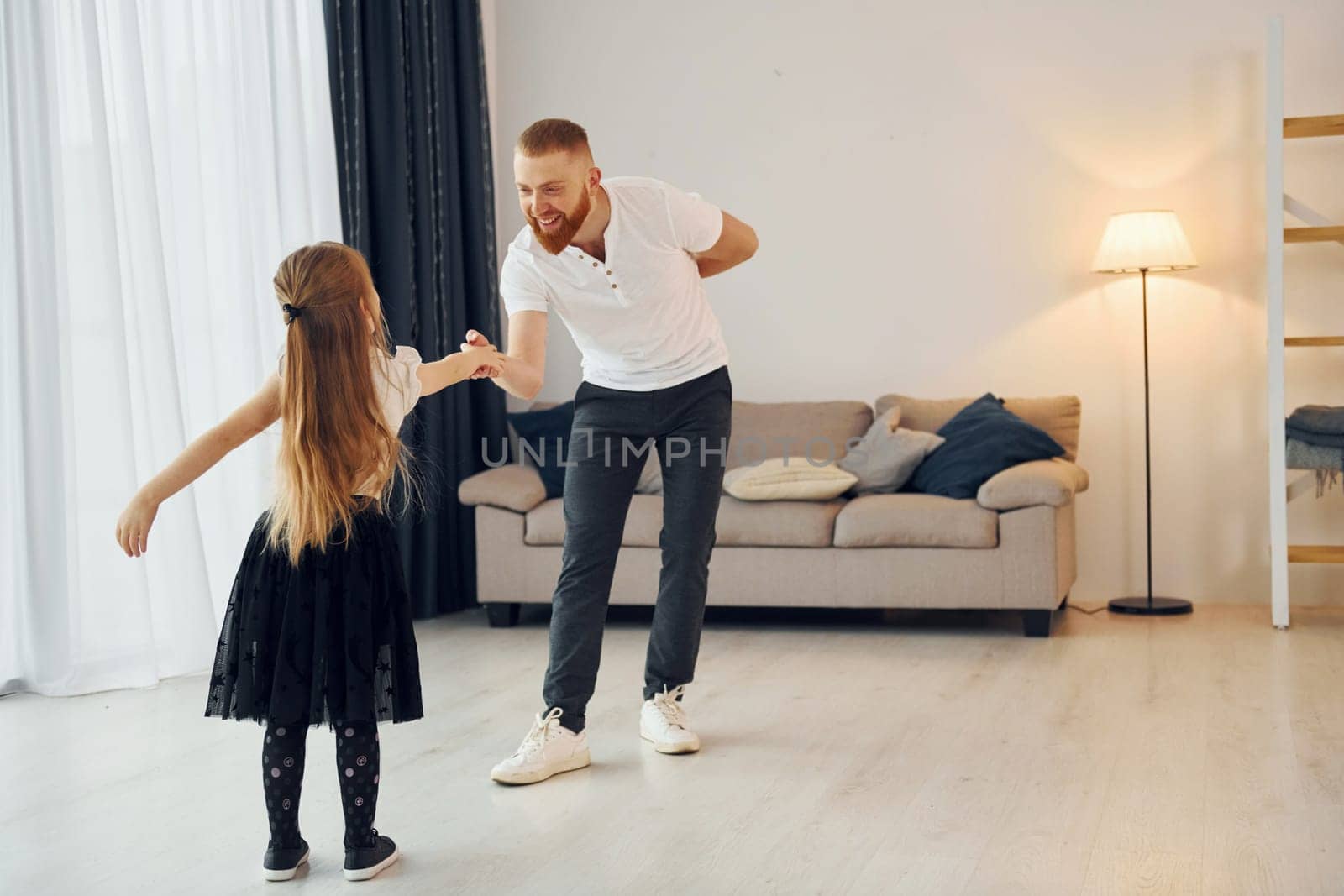 Learning to dance. Father with his little daughter is at home together.
