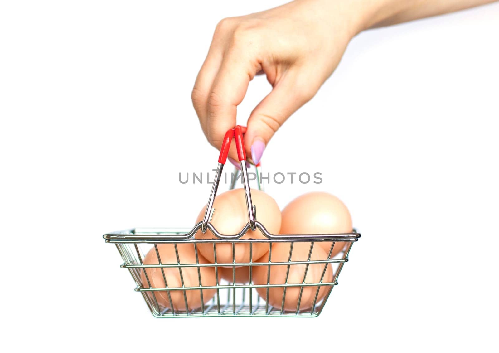 female hand holding chicken eggs in a supermarket grocery basket on a white background. Eggs in shopping cart. the concept of buying and selling eggs. High quality photo