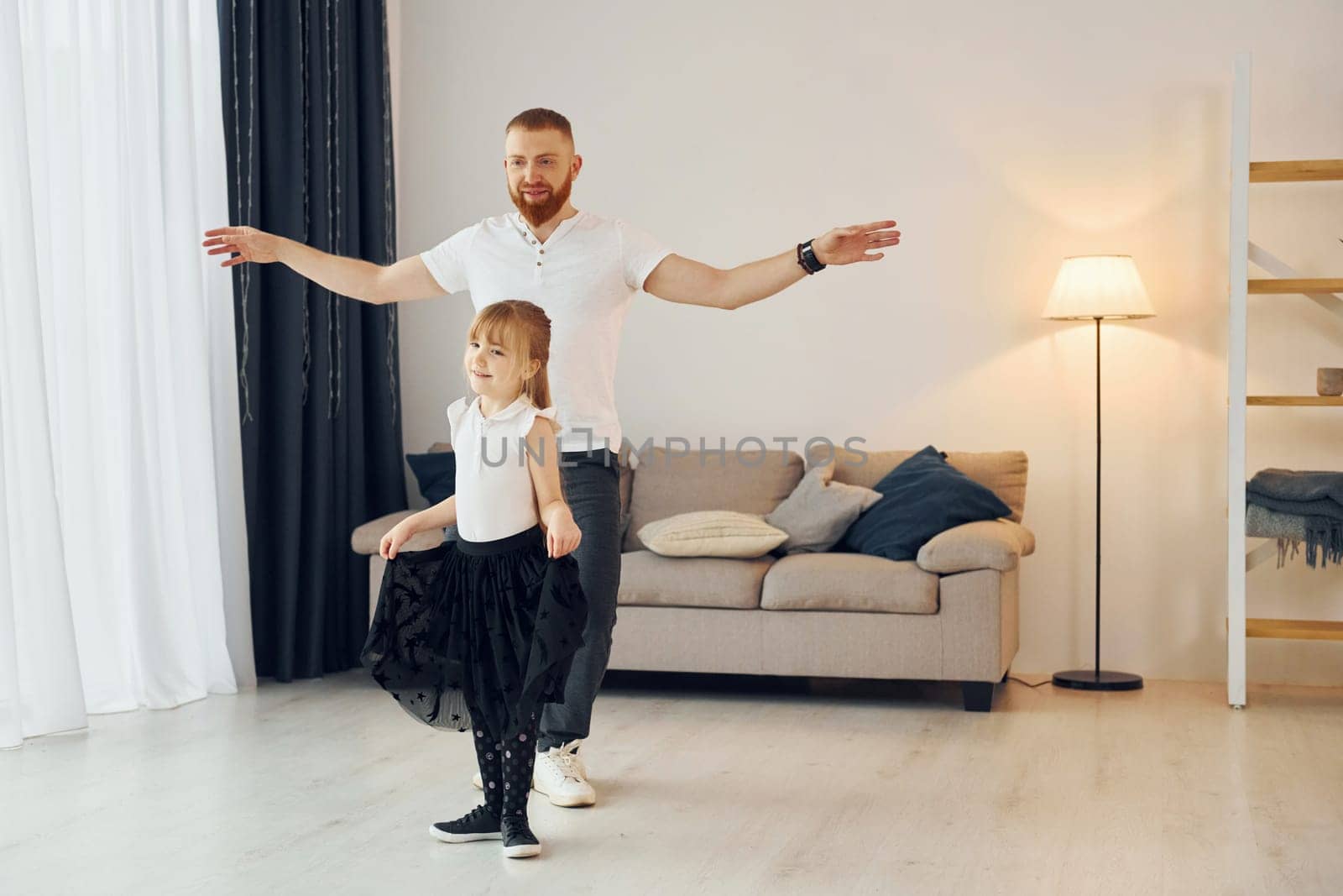 Yoga poses. Father with his little daughter is at home together by Standret