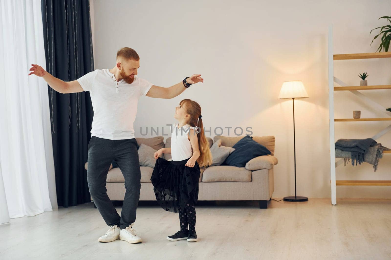 Yoga poses. Father with his little daughter is at home together.