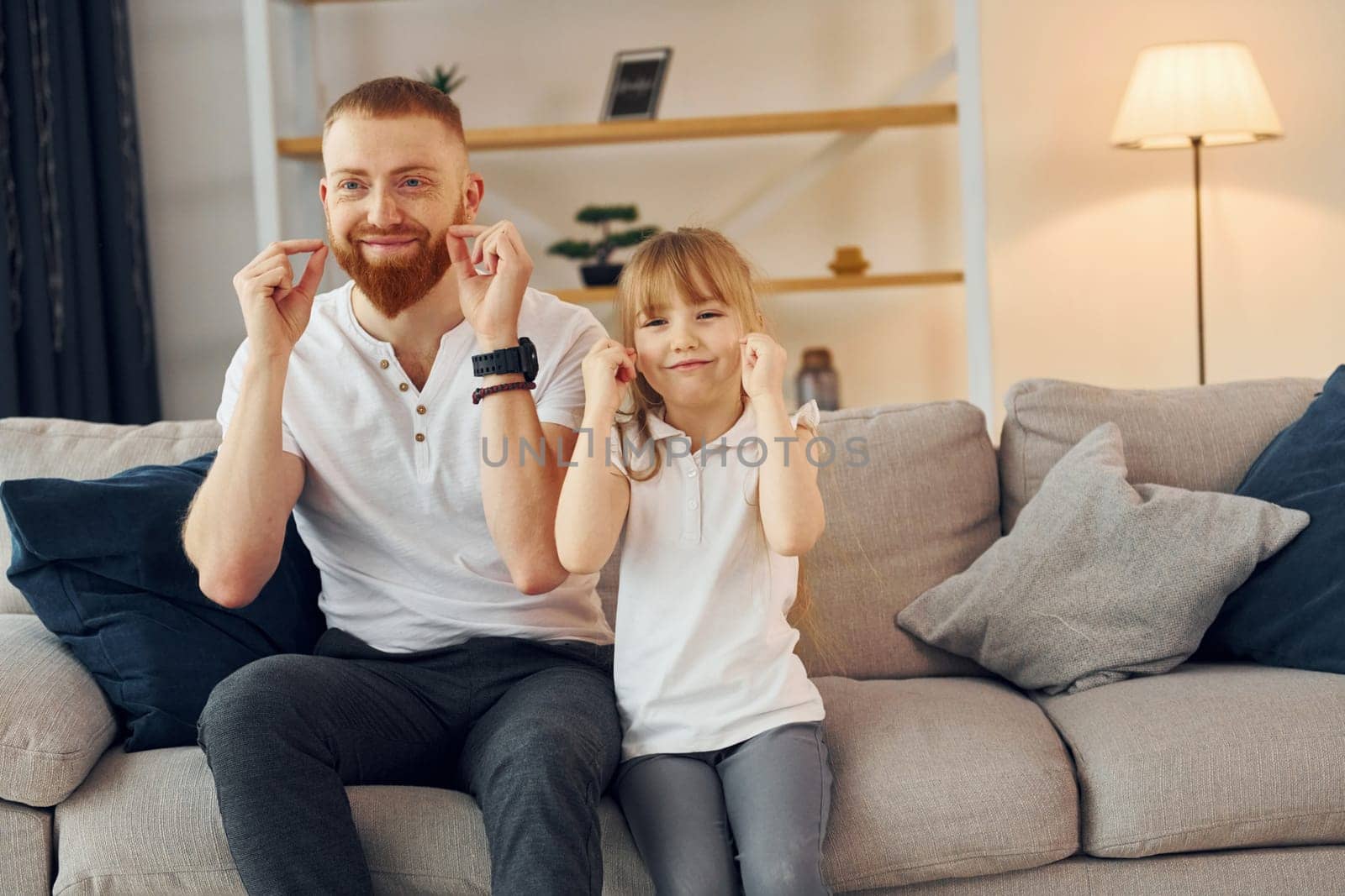 Learning to talk some words. Father with his little daughter is at home together.