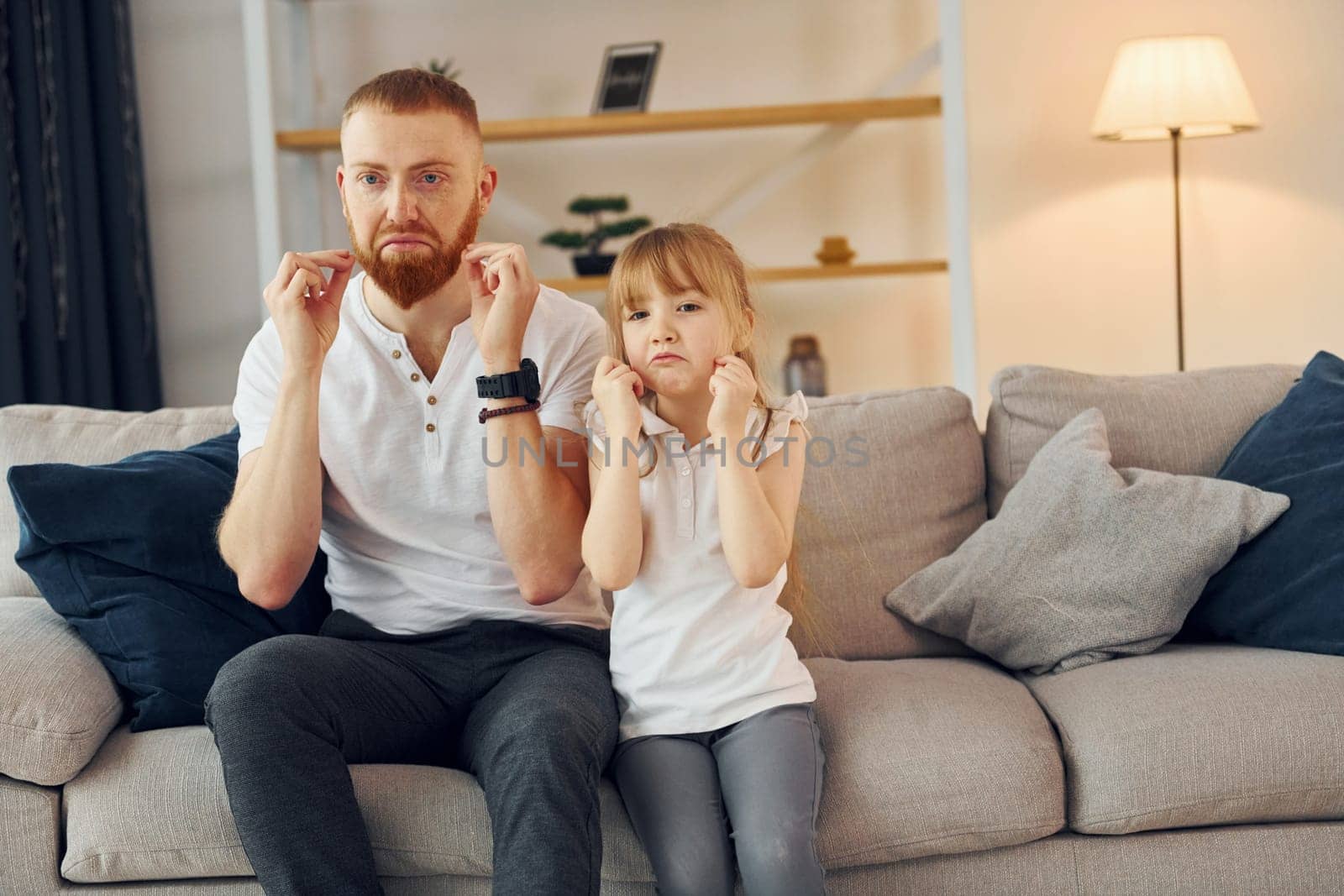 Learning to talk some words. Father with his little daughter is at home together.