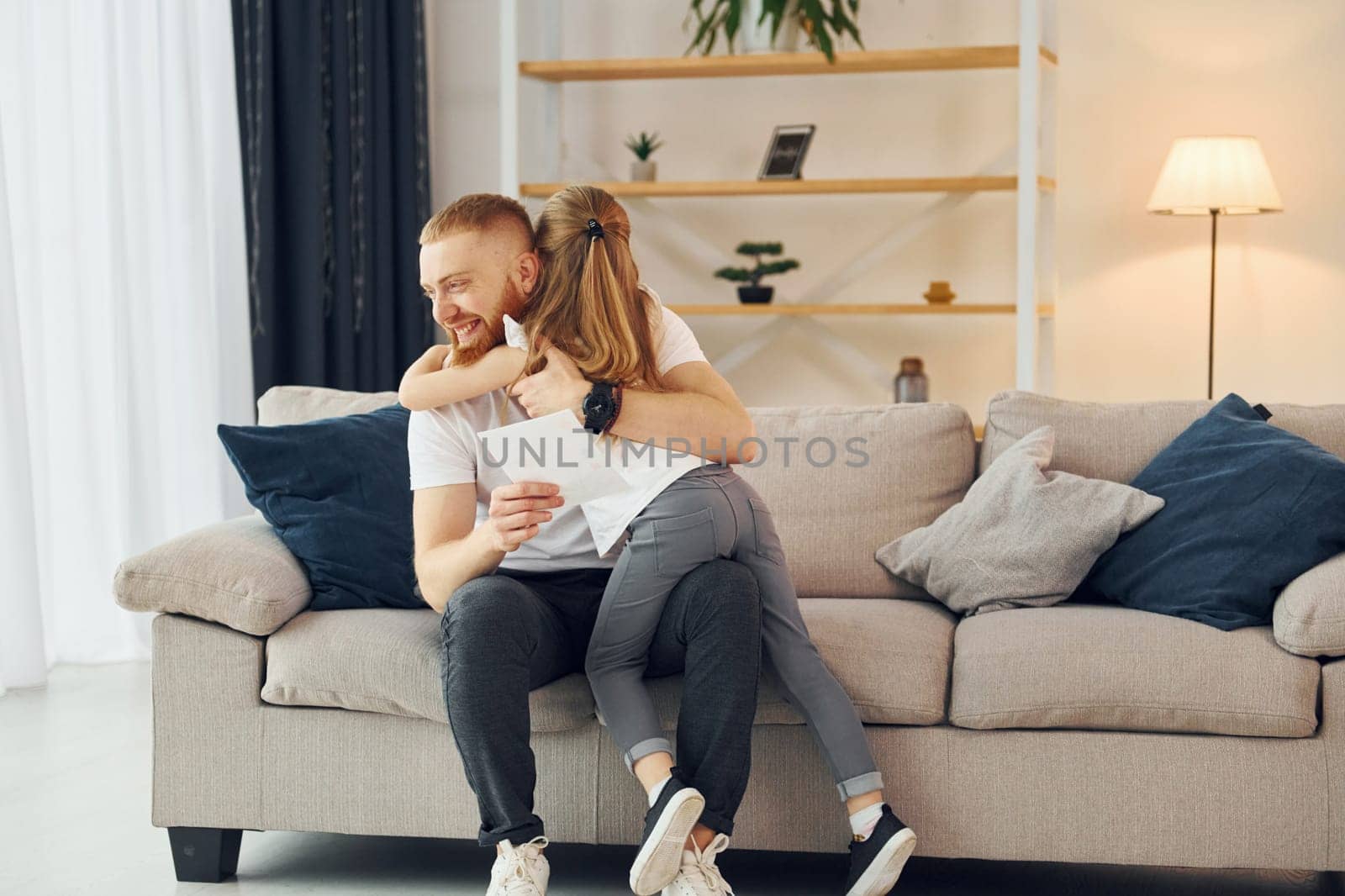 With gift box. Father with his little daughter is at home together.