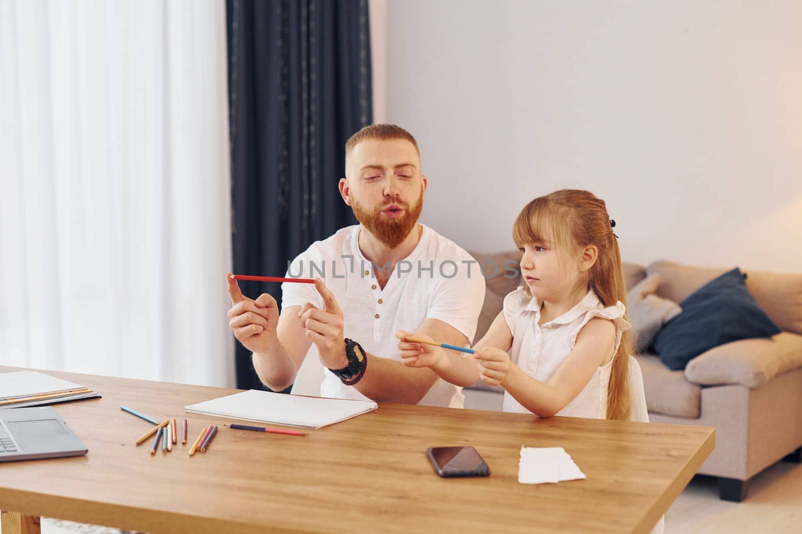 Cozy atmosphere. Father with his little daughter is at home together.