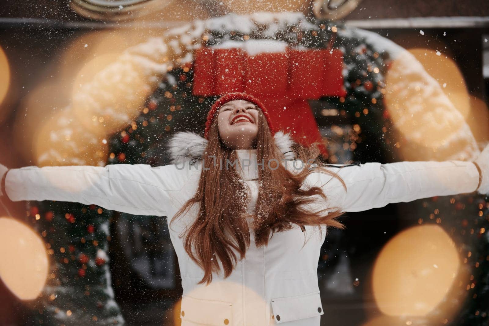 Playing with snow. Happy young woman standing outdoors and celebrating christmas holidays.