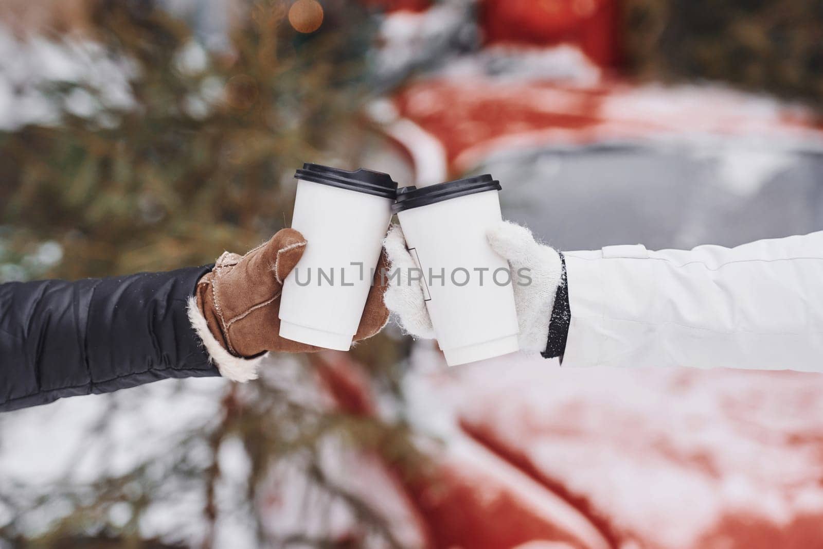 Focused close up view of women's hands that holding two cups of drink.