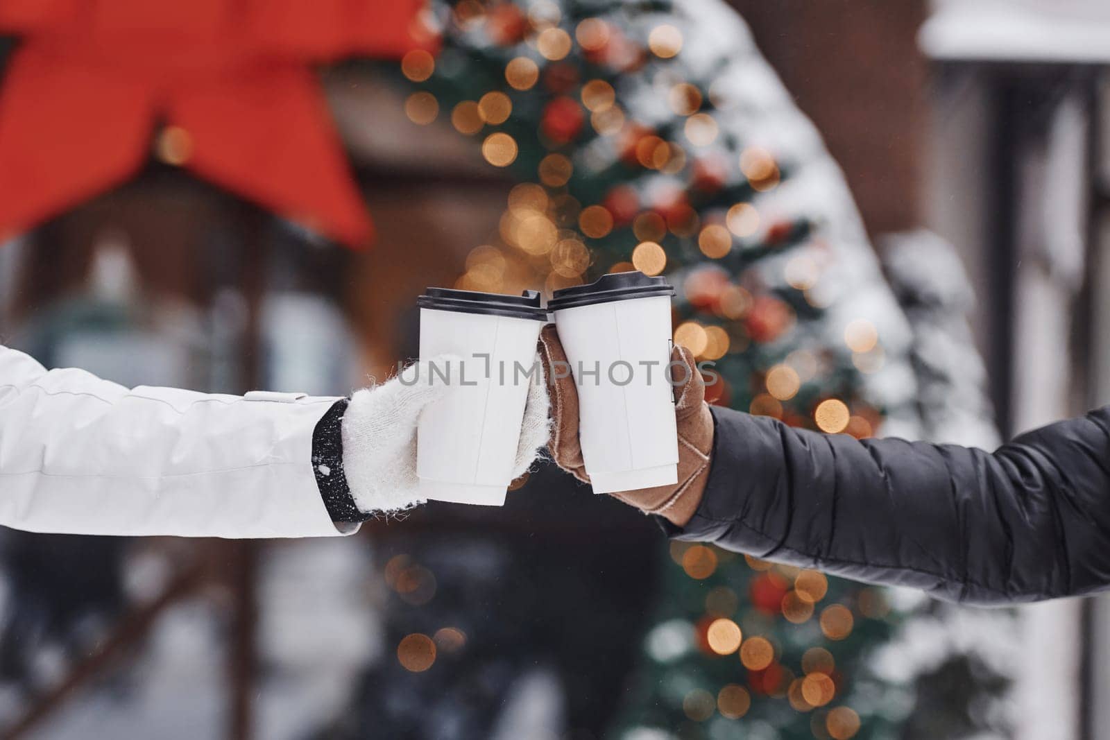 Close up view of women's hands that holding two cups of drink.