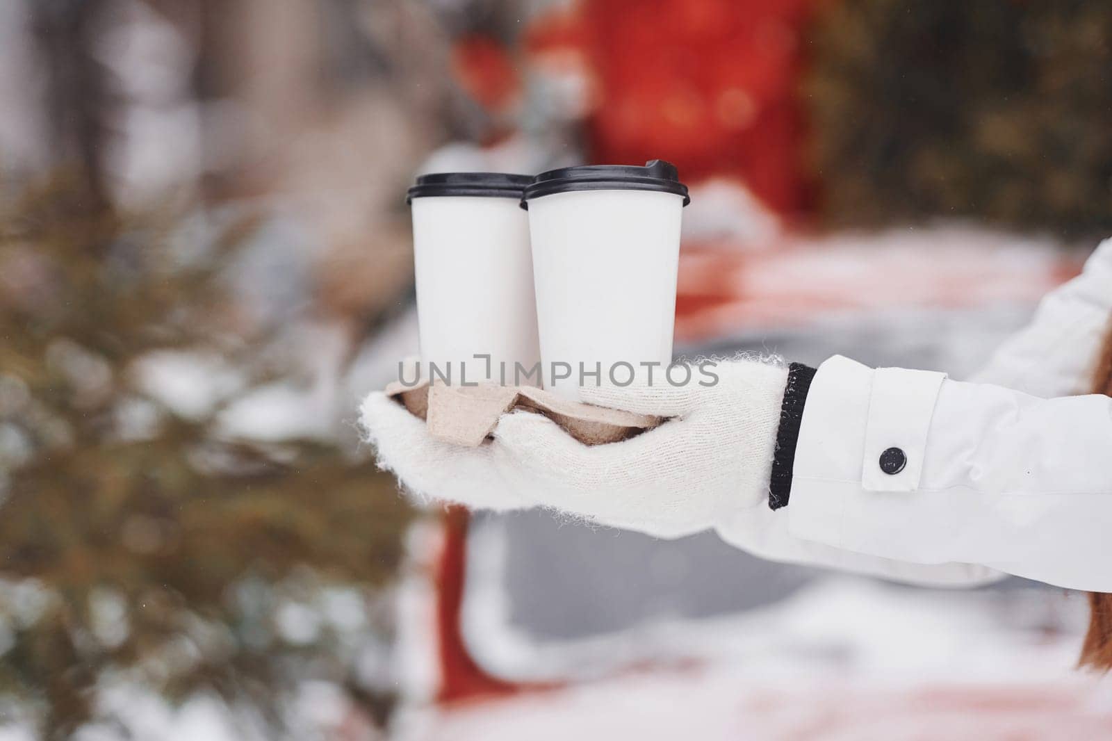 Close up view of woman's hands that holding two cups of drink.