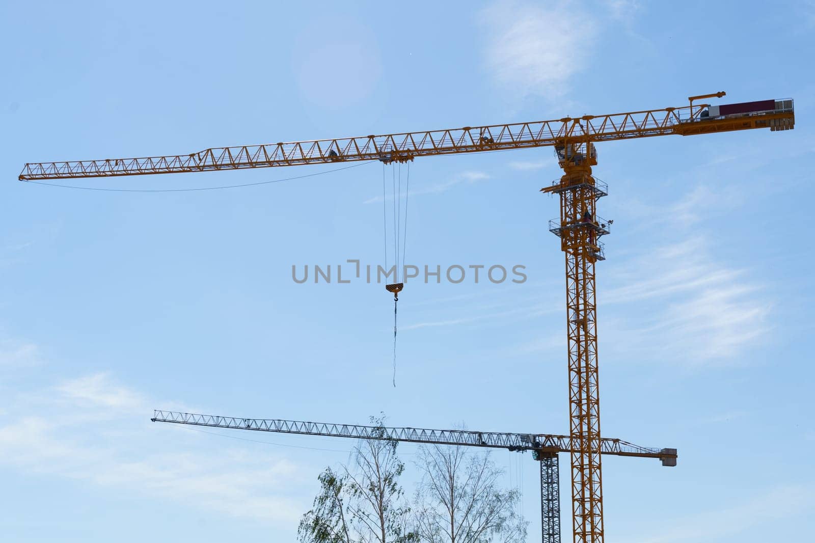 Construction cranes against the blue sky. Bottom view. Building concept.