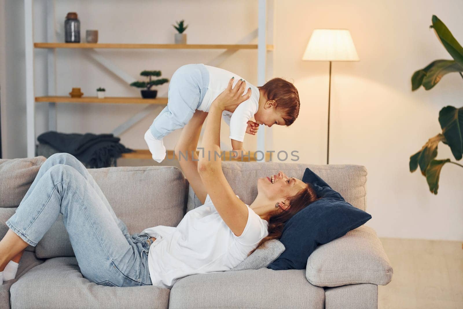 Woman holding little girl in hands. Mother with her little daughter is at home together.