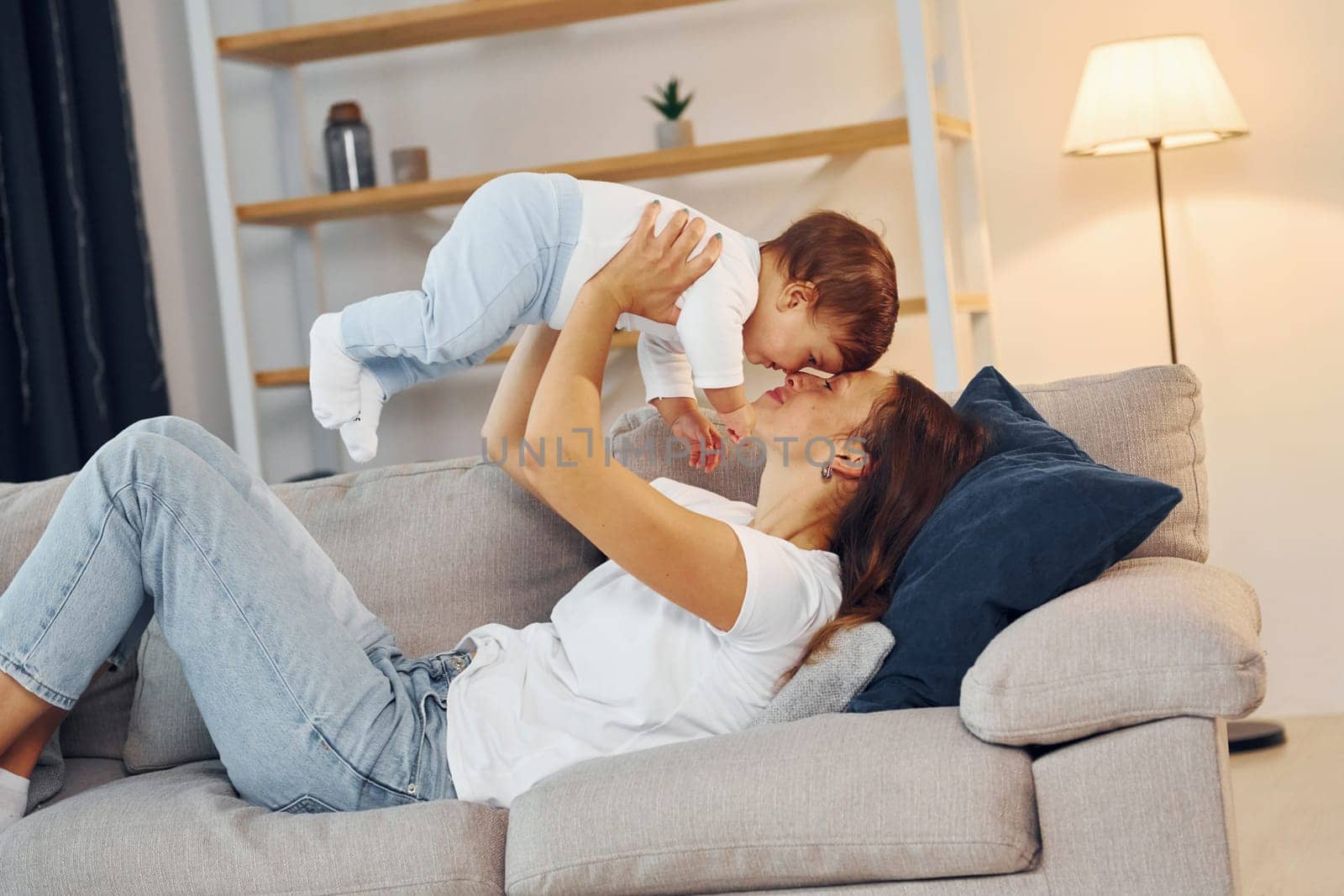 Woman holding little girl in hands. Mother with her little daughter is at home together.