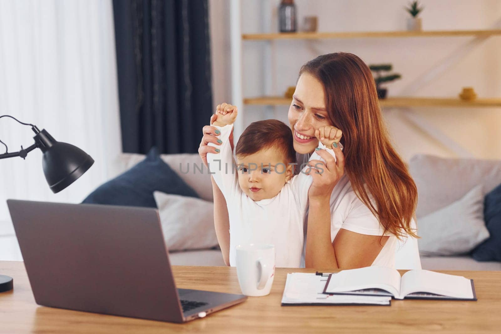 Mother with her little daughter is at home together.