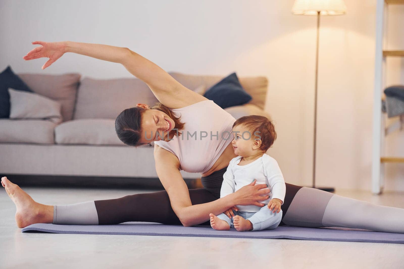 Teaching fitness. Mother with her little daughter is at home together.