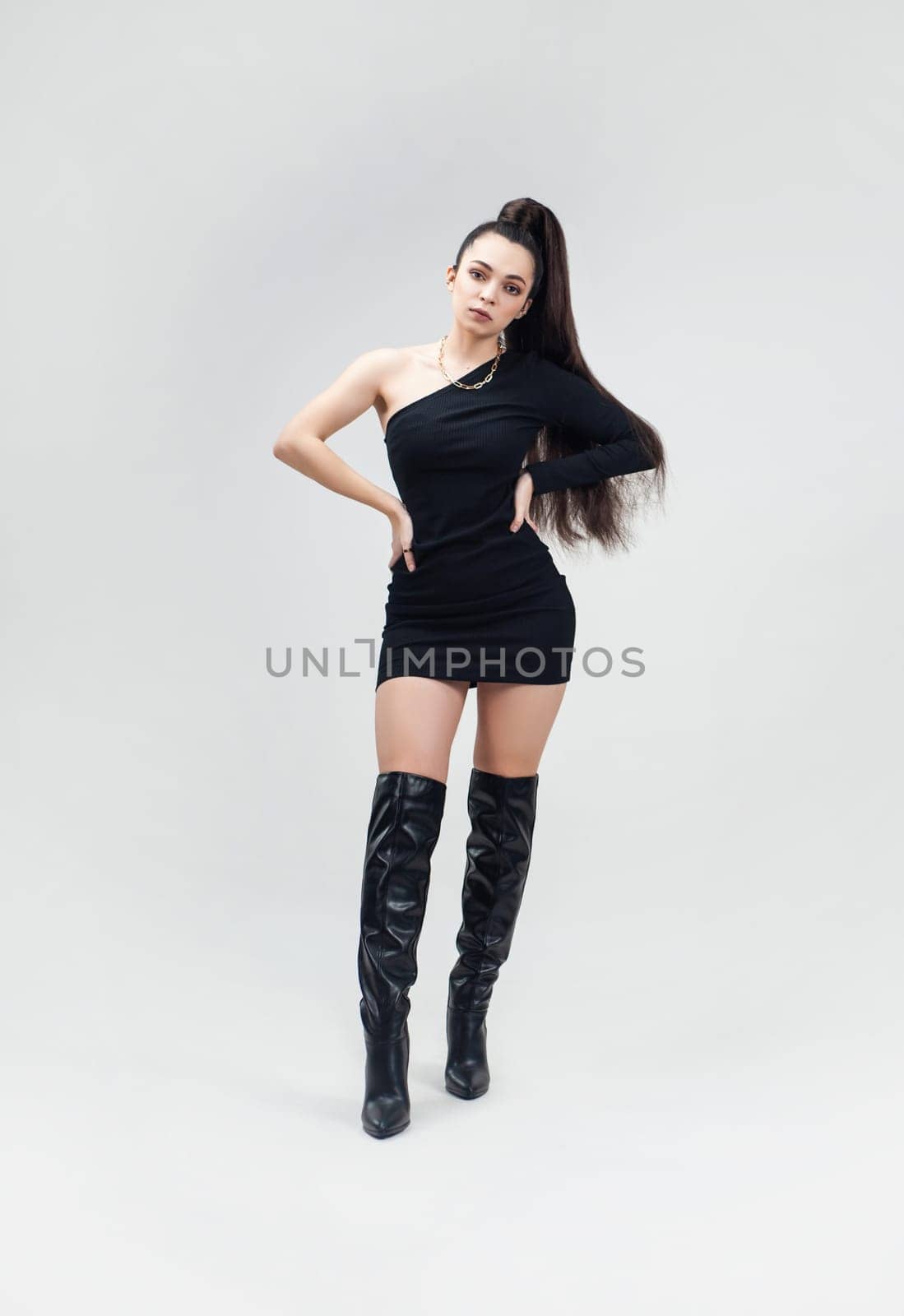 sexy girl in a short black dress and high boots on a light empty background of a copy paste by Rotozey