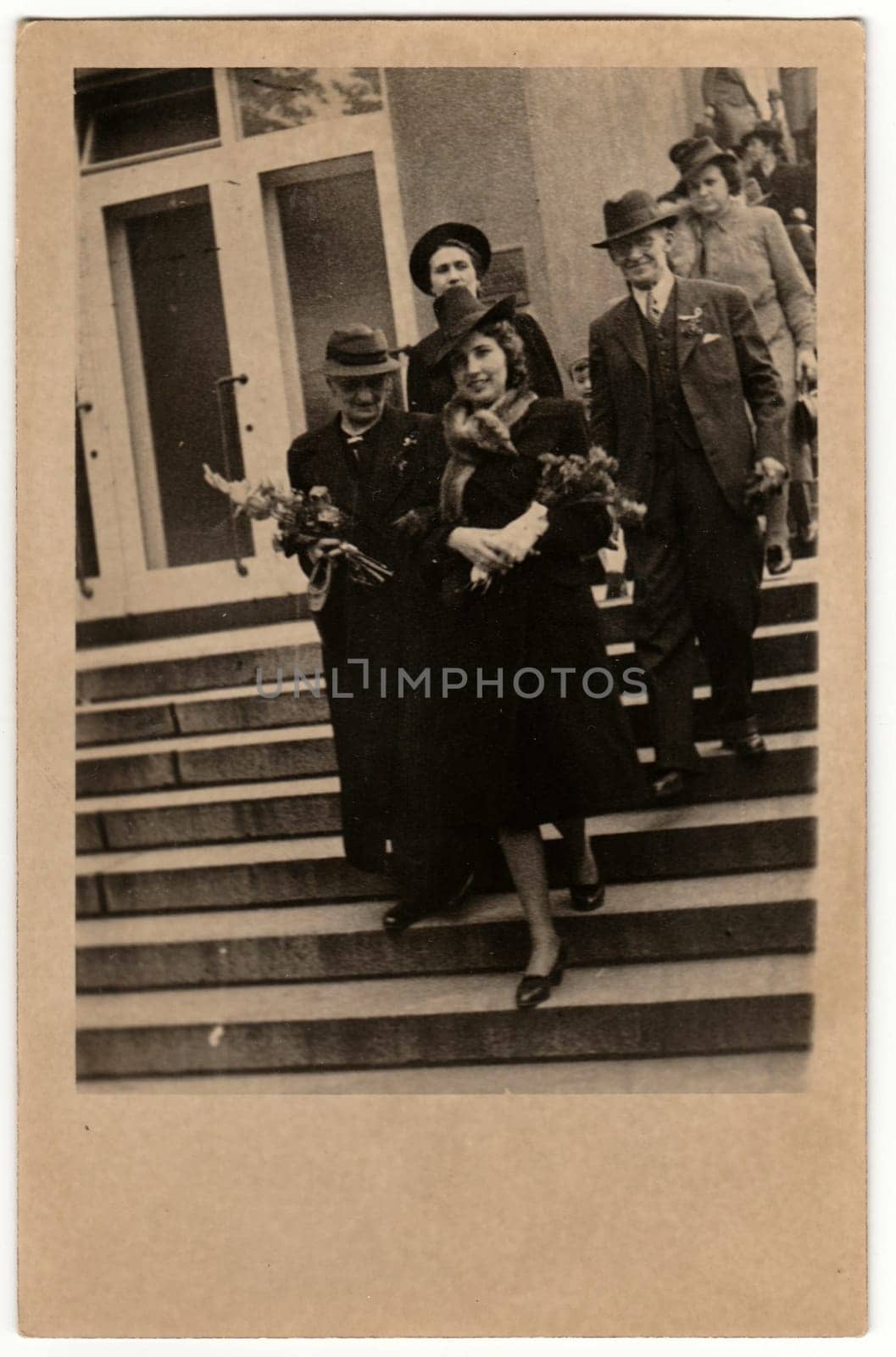 Vintage photo shows people go from wedding ceremony. Retro black and white photography. Circa 1950s. by roman_nerud