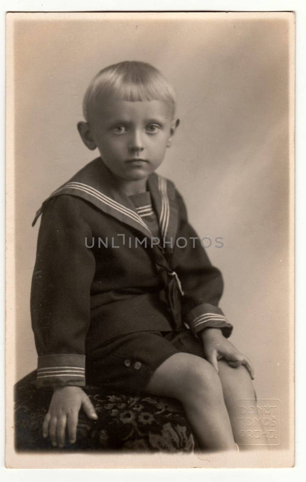 Vintage photo shows a young boy wears sailor costume. Retro black and white photography. Circa 1950s. by roman_nerud