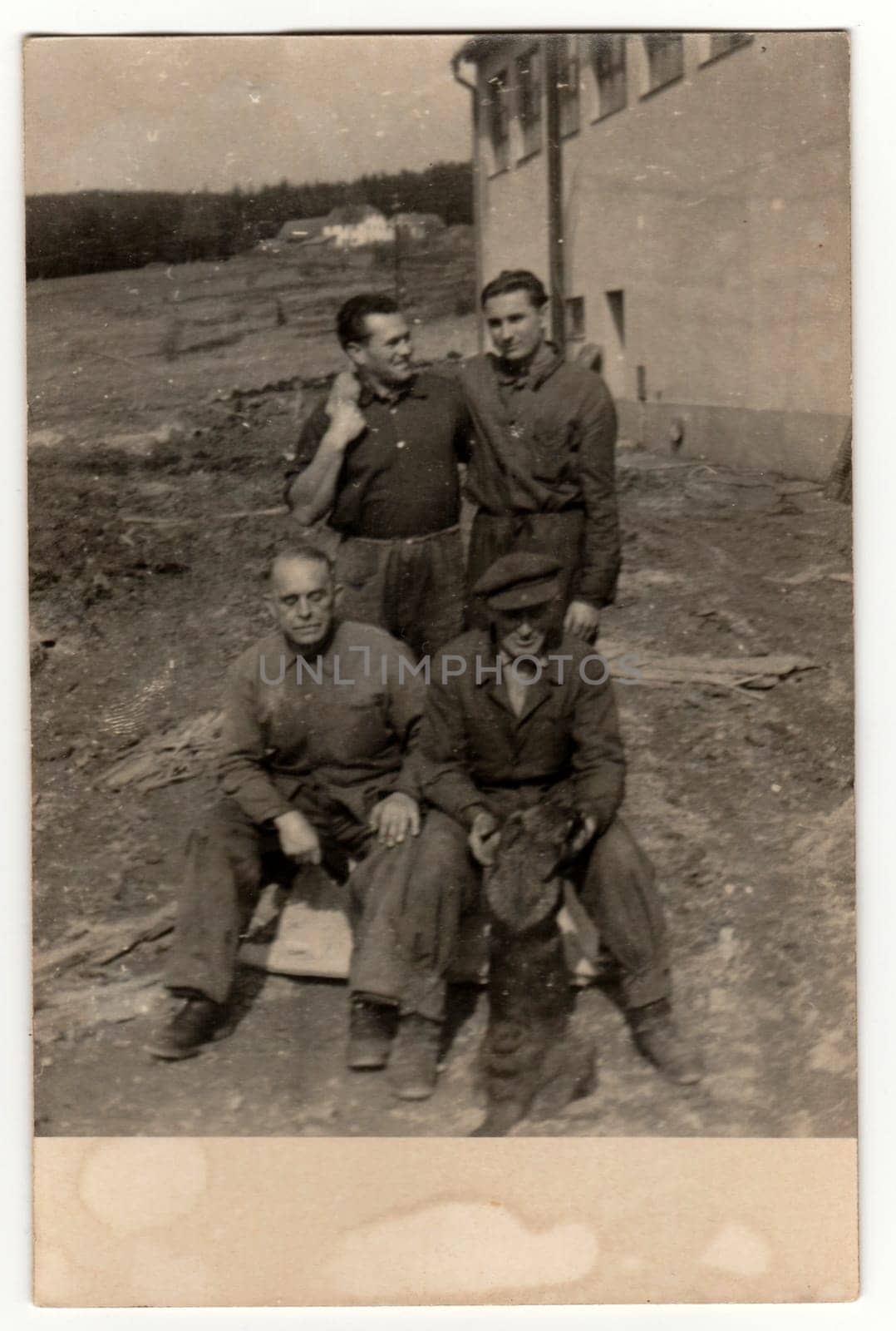 Vintage photo shows a group of workers - labours poses outdoor. Retro black and white photography. Circa 1940s. by roman_nerud