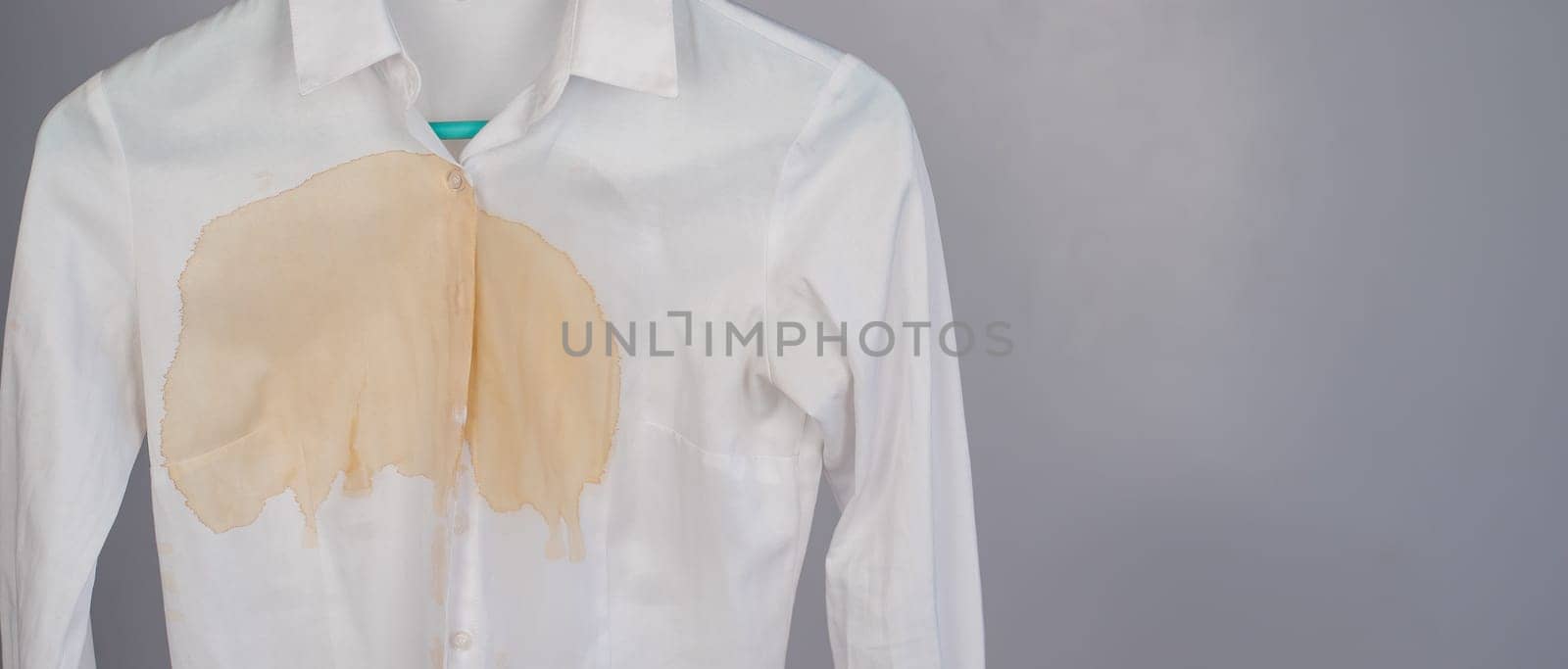 Women's office white shirt with a stain of coffee on a white background. Copy space