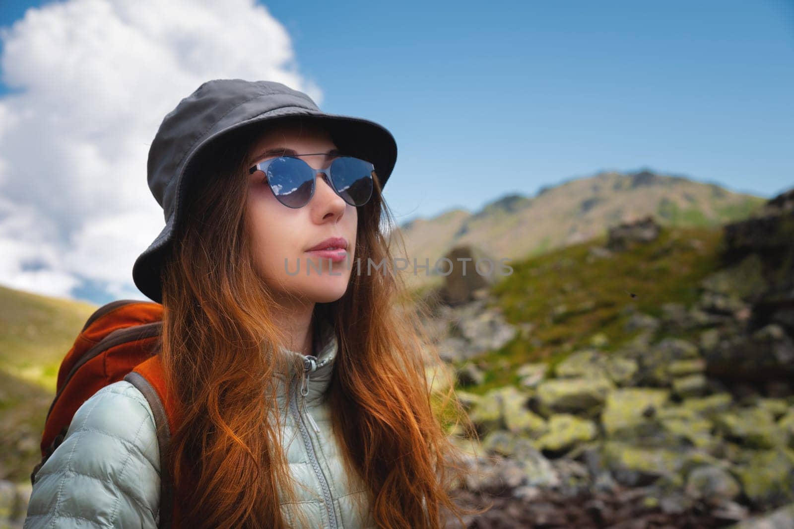 Happy, woman and female student with a backpack outdoors in the mountains resting during the holidays. freedom concept. Portrait of a girl in sunglasses during a walk by yanik88