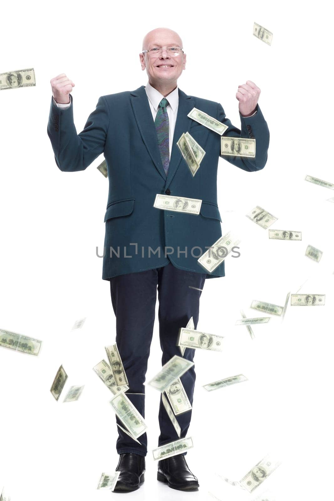 in full growth. happy business man standing in the rain of dollar bills. isolated on a white background.