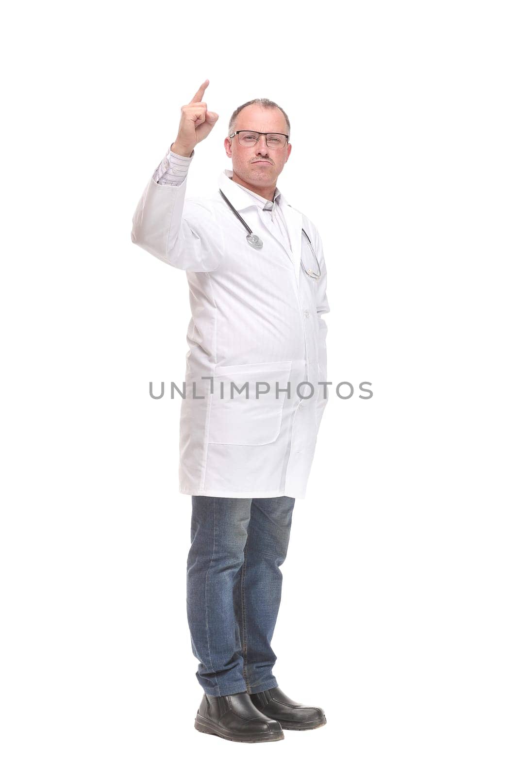 Cheerful mature doctor looking at camera and pointing away while standing against white background