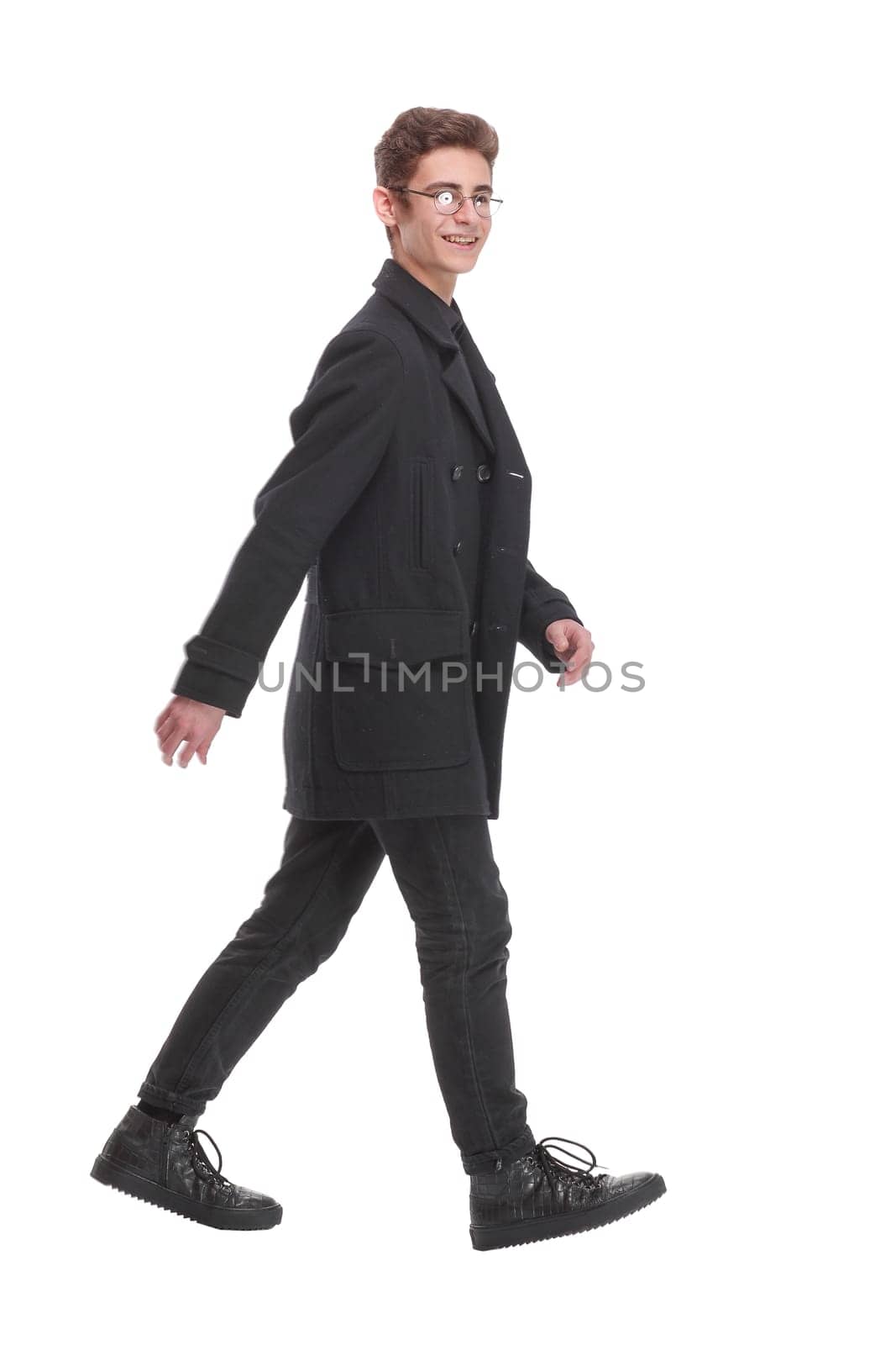 Side view of a fashion young man walking forward over white. Isolated over white background