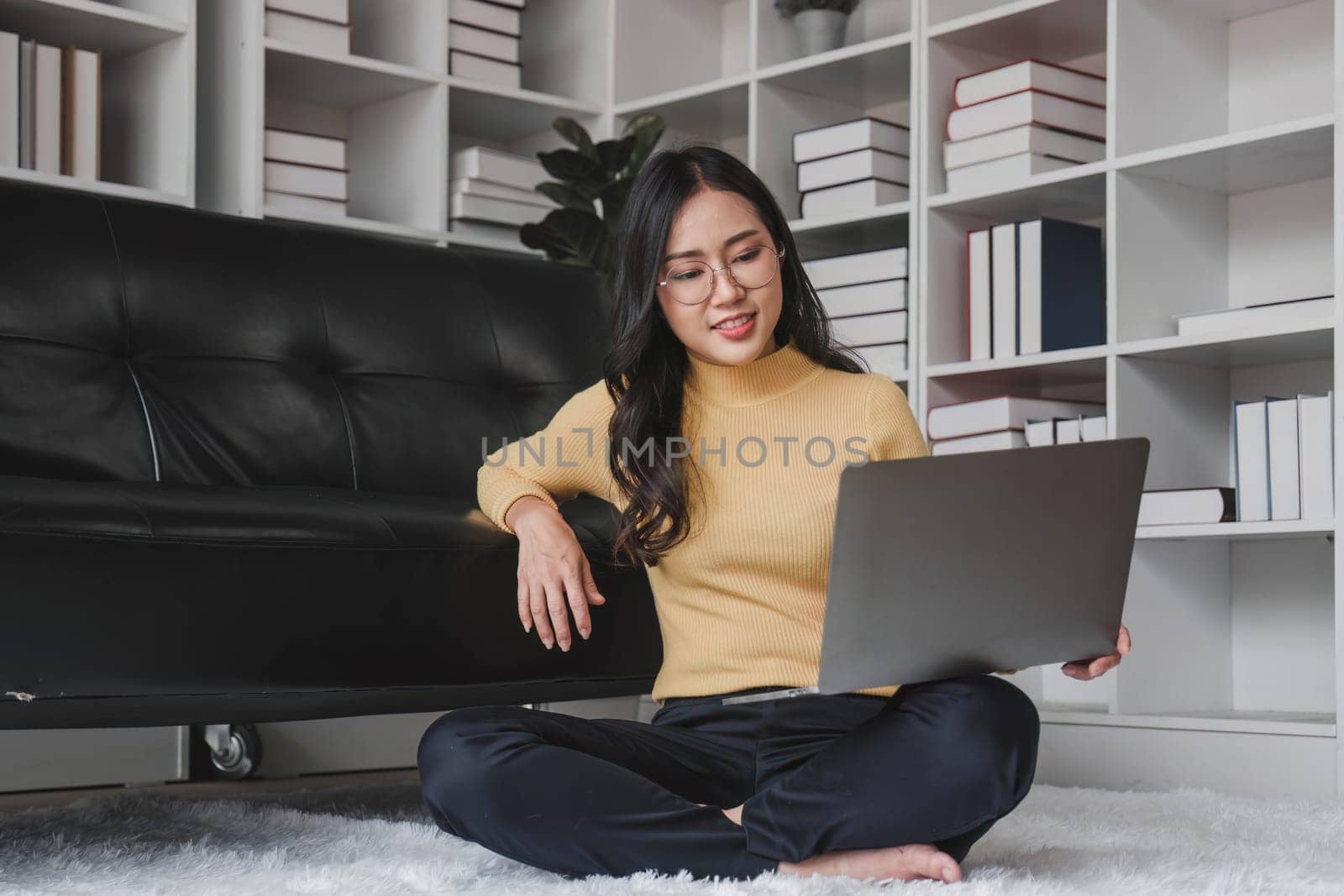 Happy young Asian business woman successful excited raised hand rejoicing with laptop at home...