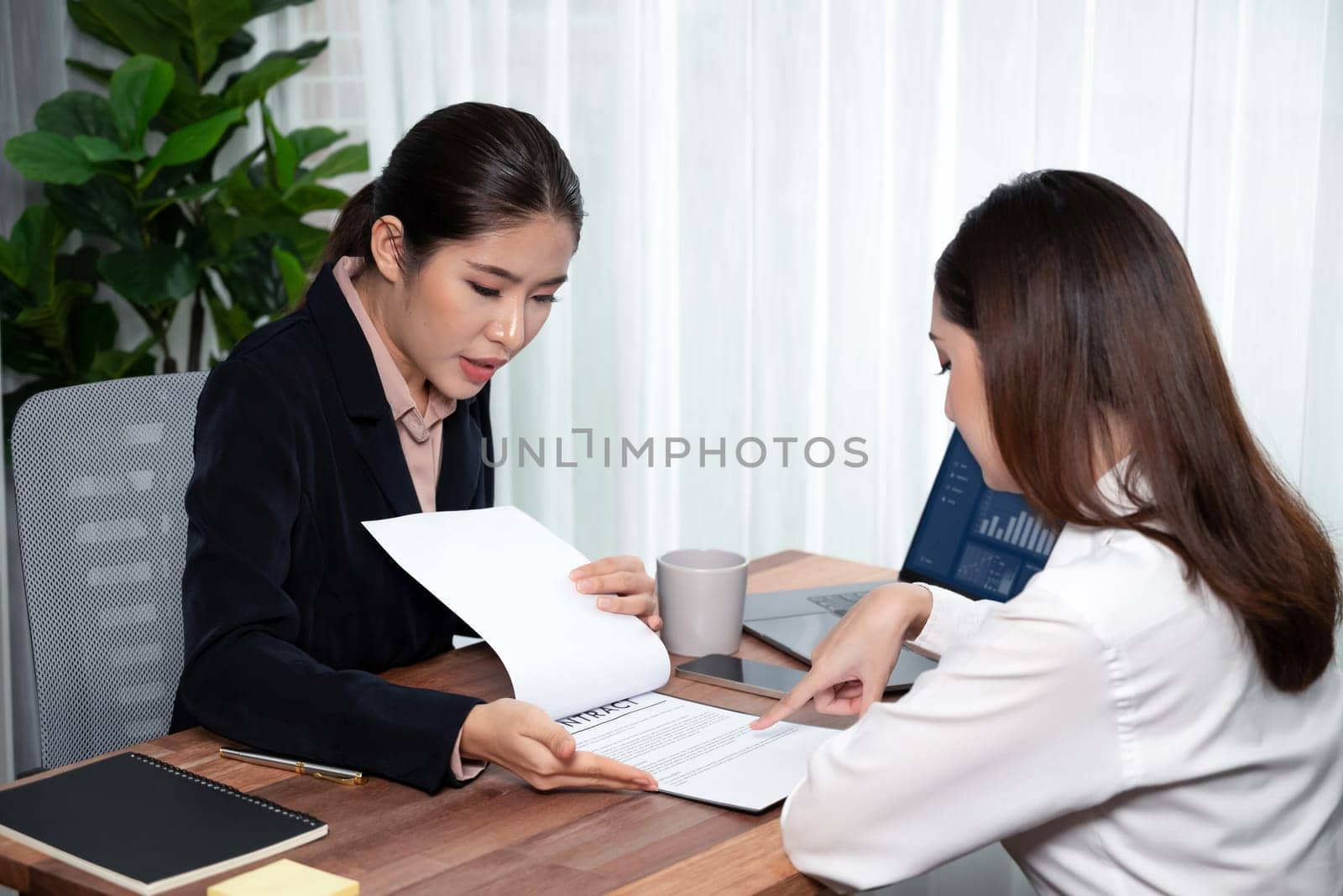 Business deal meeting, young businesswomen carefully reviewing terms and condition of contract agreement papers in office. Corporate lawyer give consultation on contract deal. Enthusiastic