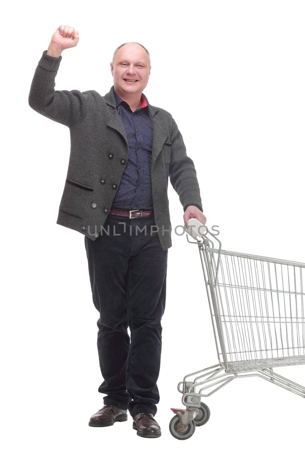 in full growth.smiling casual man with shopping cart .isolated on a white background.