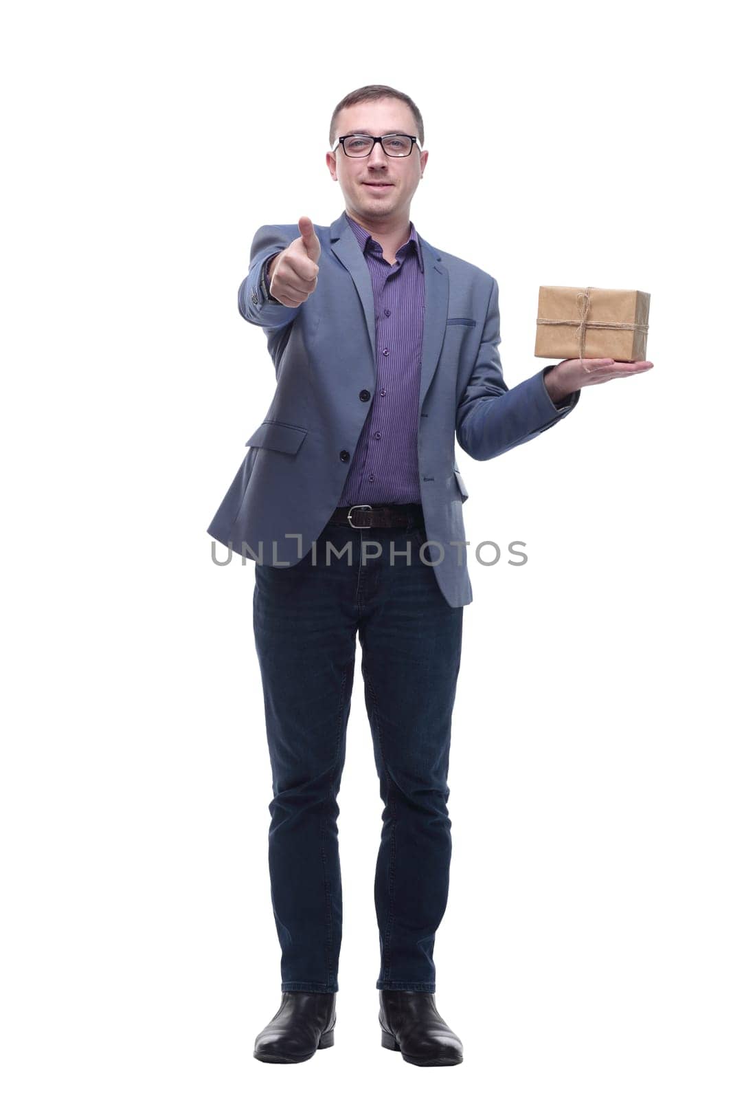 Cheerful handsome well-dressed young man in glasses holding gift box and looking at camera with smile while standing against white background