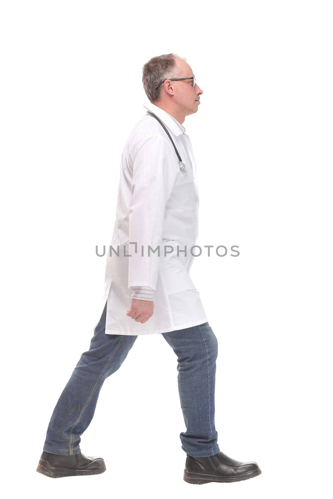 Middle age male doctor walking away and look at camera isolated on white. Concept of health care