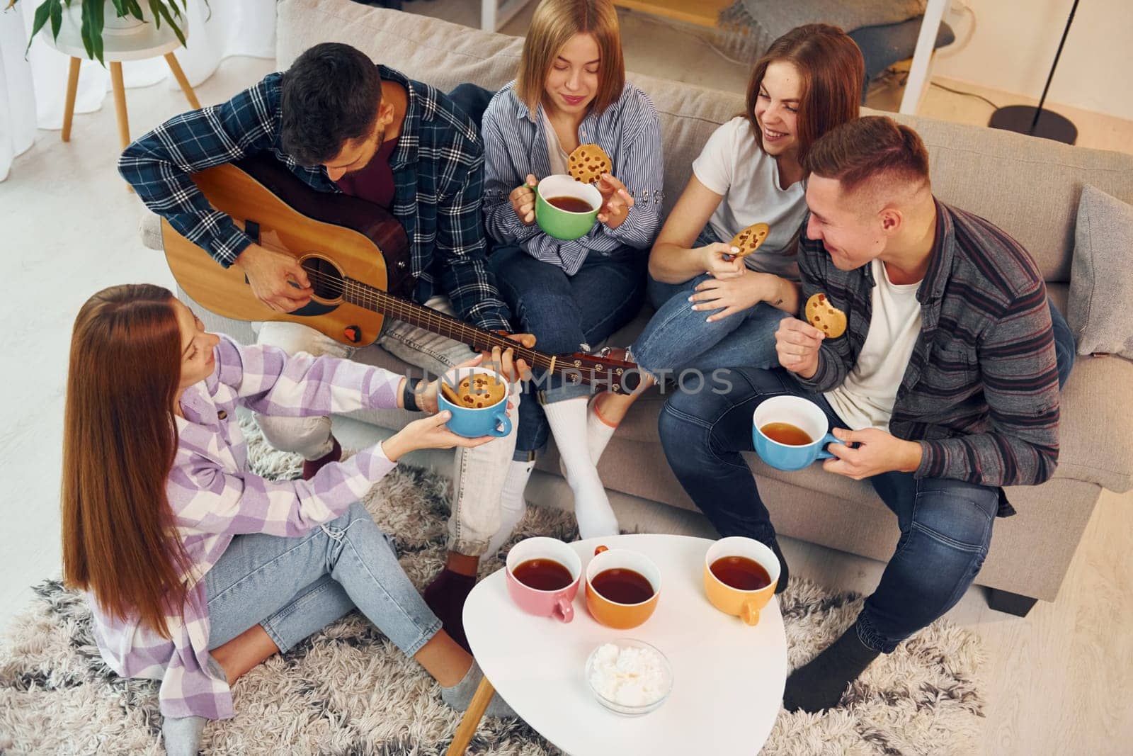 In domestic room. Group of friends have party indoors together.