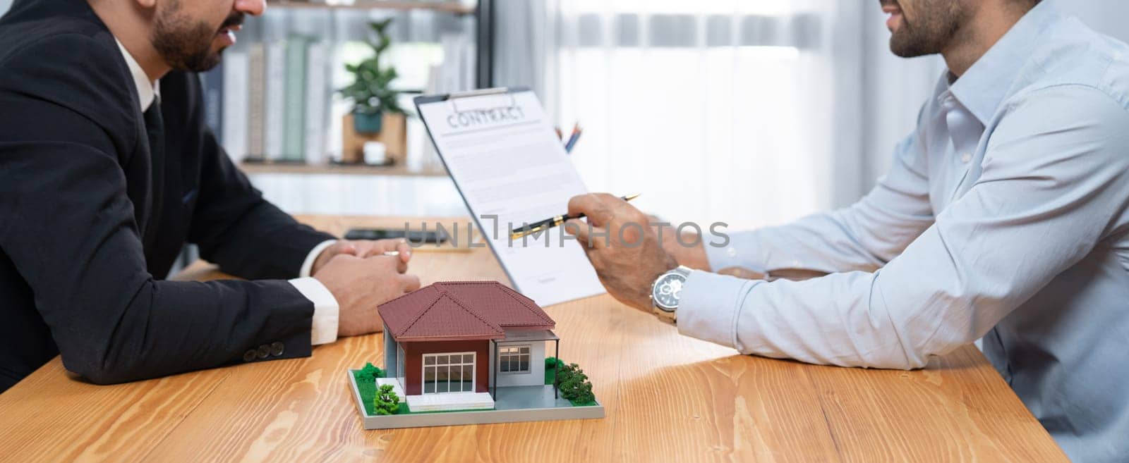 Client review loan contract with real estate agent, discussing term, interest and property ownership. Analyzing legal document, reading agreement before deciding. Real estate transaction. Fervent