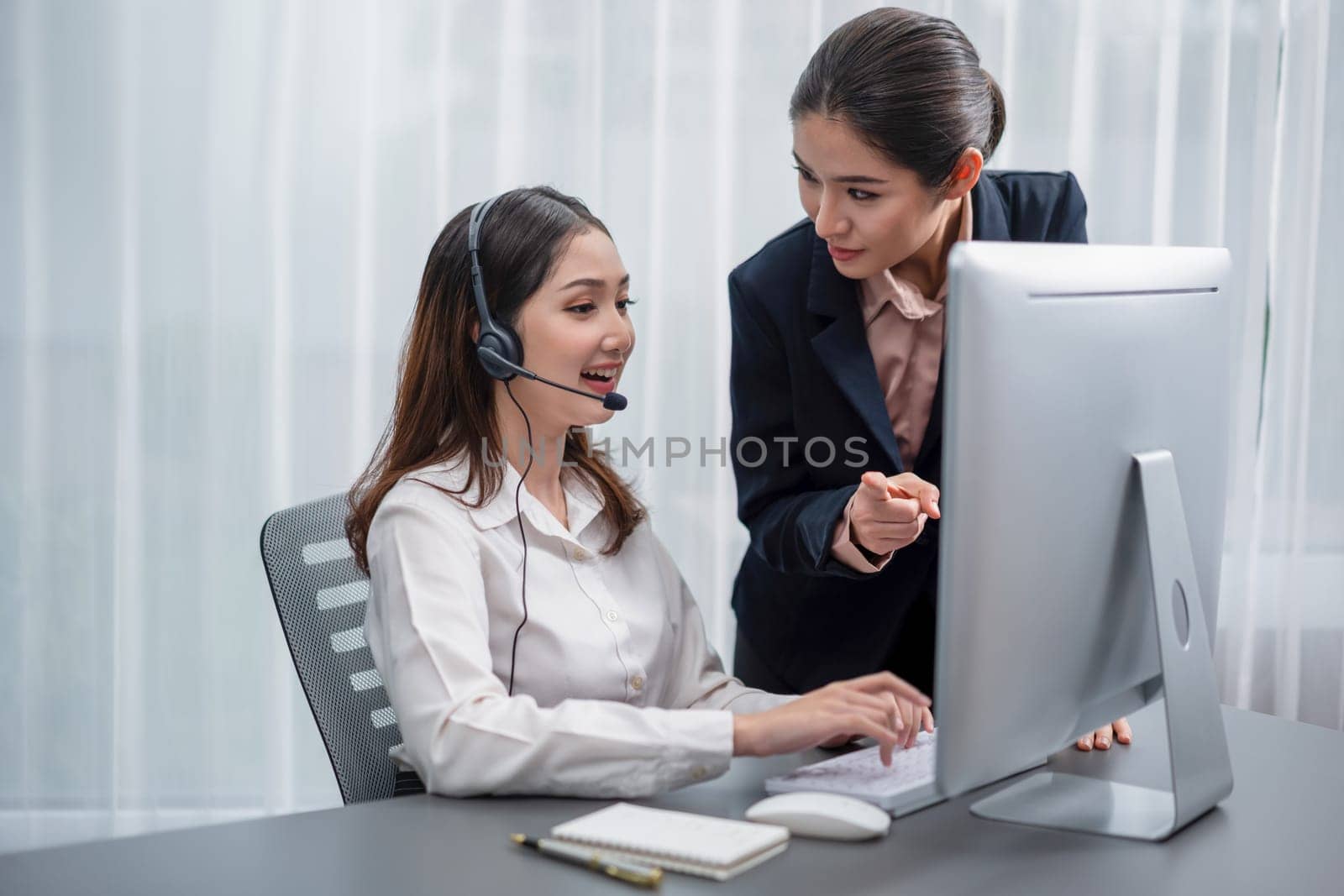 Asian female customer support operator guided by manger Enthusiastic by biancoblue
