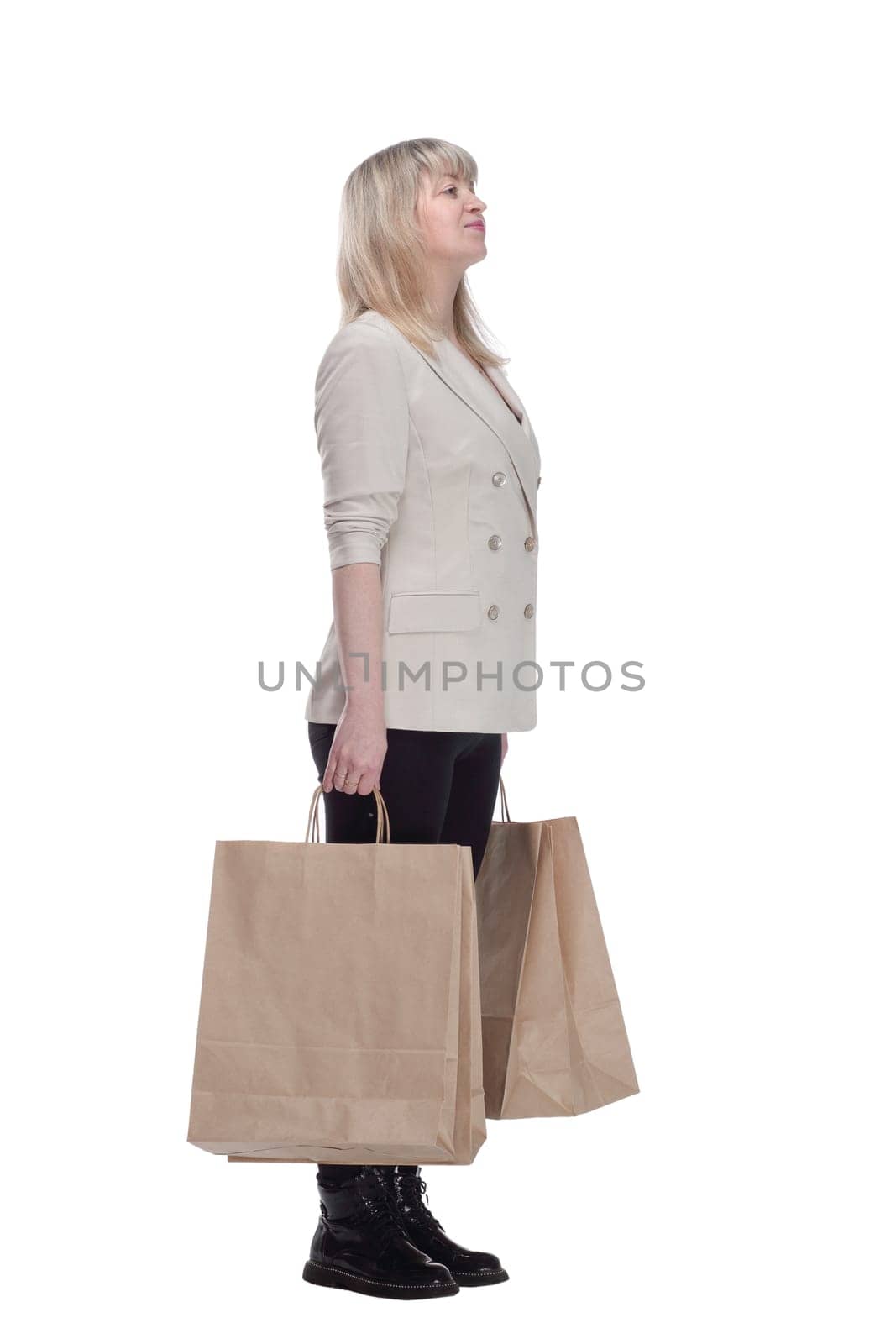 side view. attractive mature woman with shopping bags . isolated on a white background.