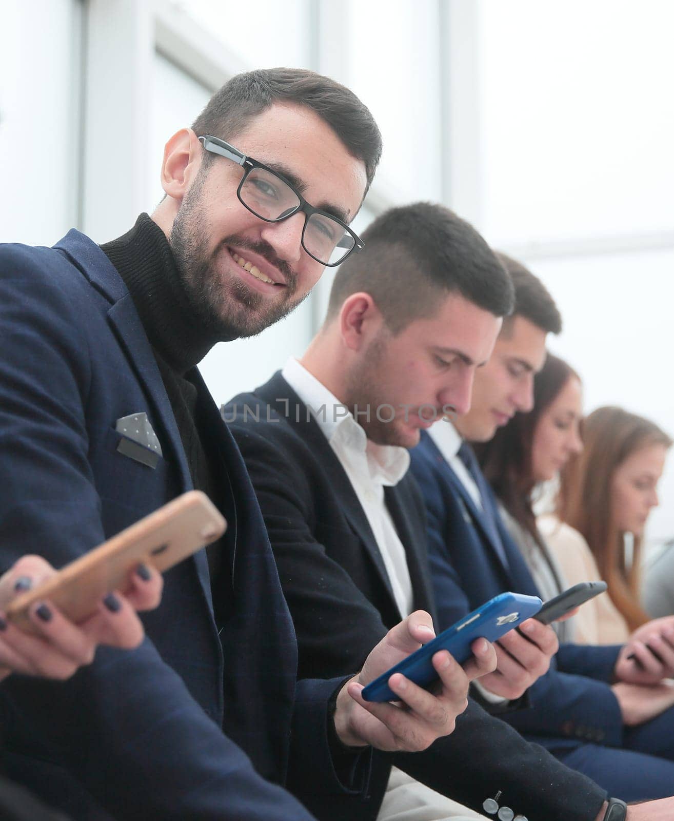 close up. group of young business people looking at their smartphone screens.