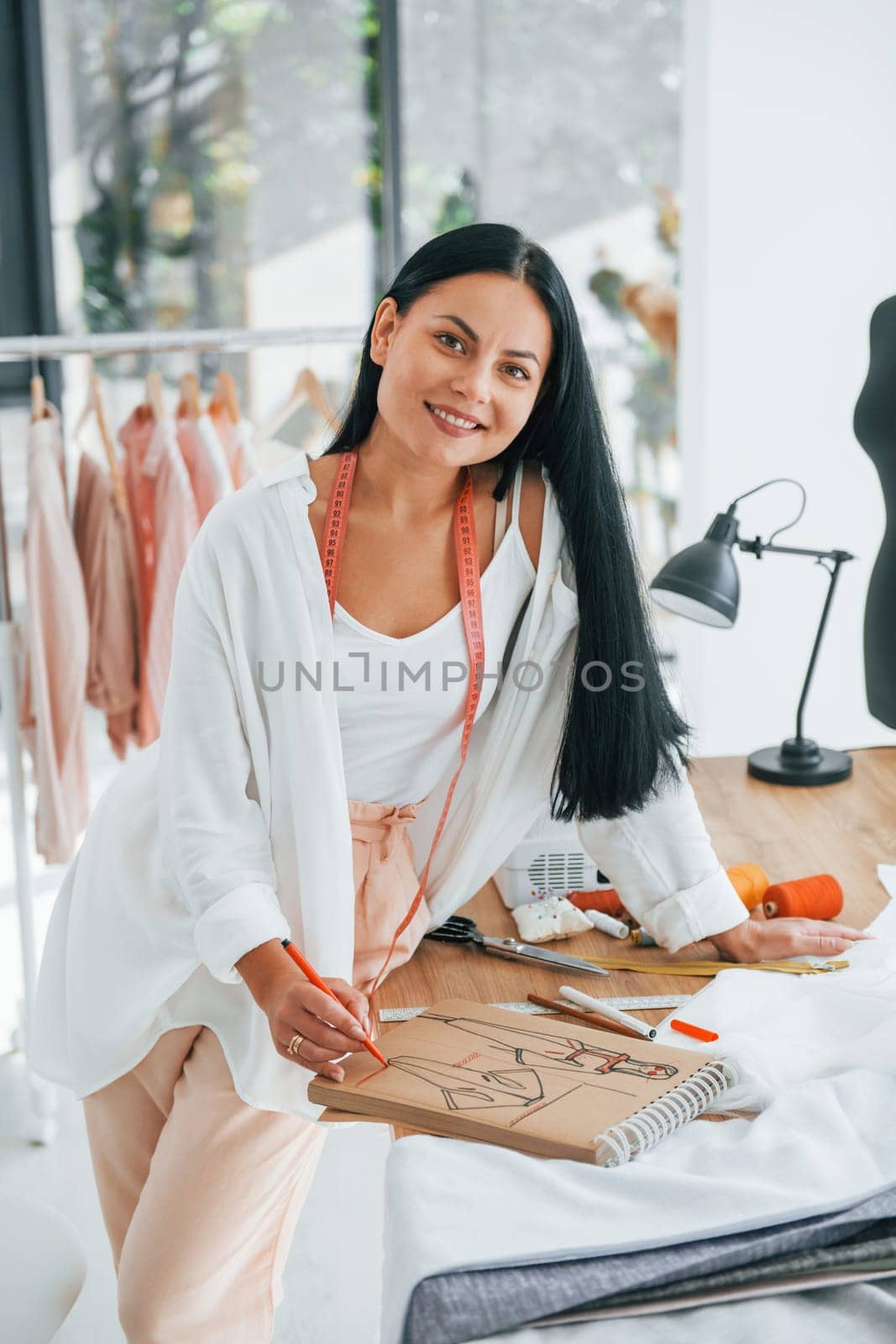 Busy at work. Seamstress is in her office that is with different clothes.
