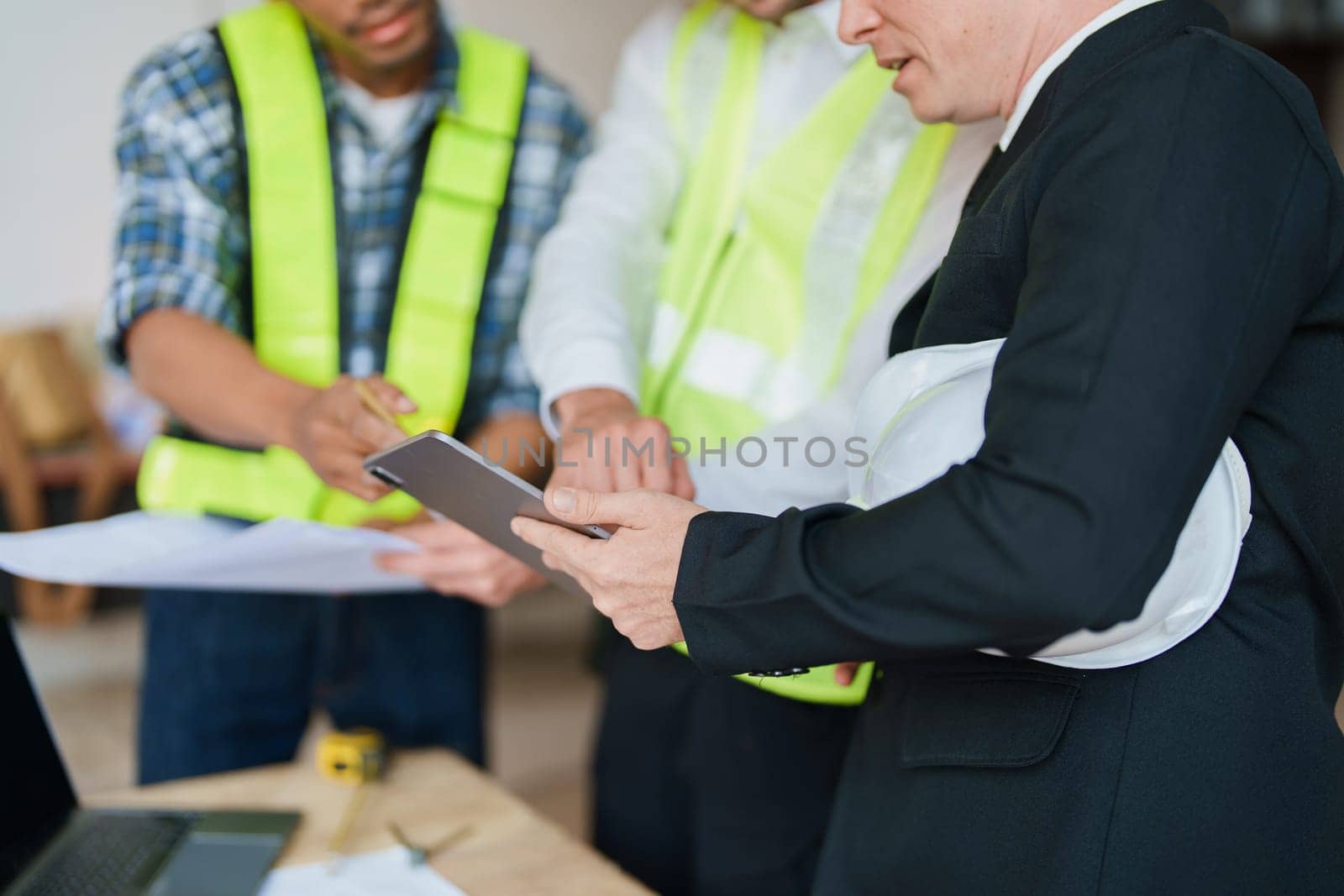 multi ethnic engineer brainstorming and measuring for cost estimating on paperworks and floor plan drawings about design architectural and engineering for houses and buildings.