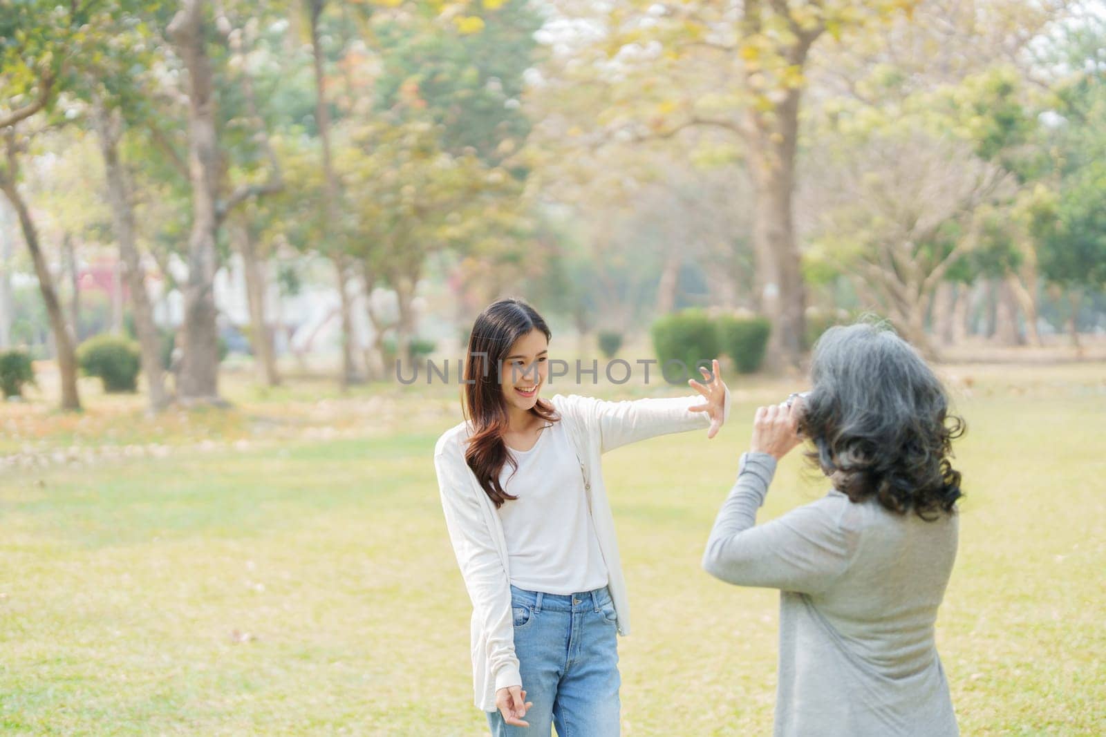 Asian teenage mother and daughter walking in park with camera to capture memories by Manastrong