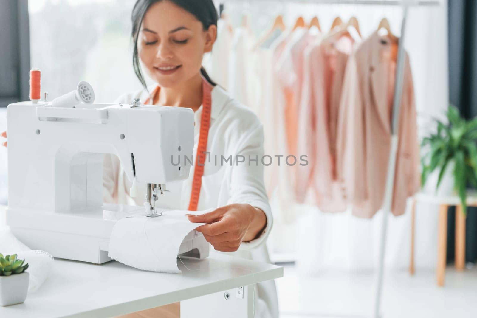 Professional equipment. Seamstress is in her office that is with different clothes.