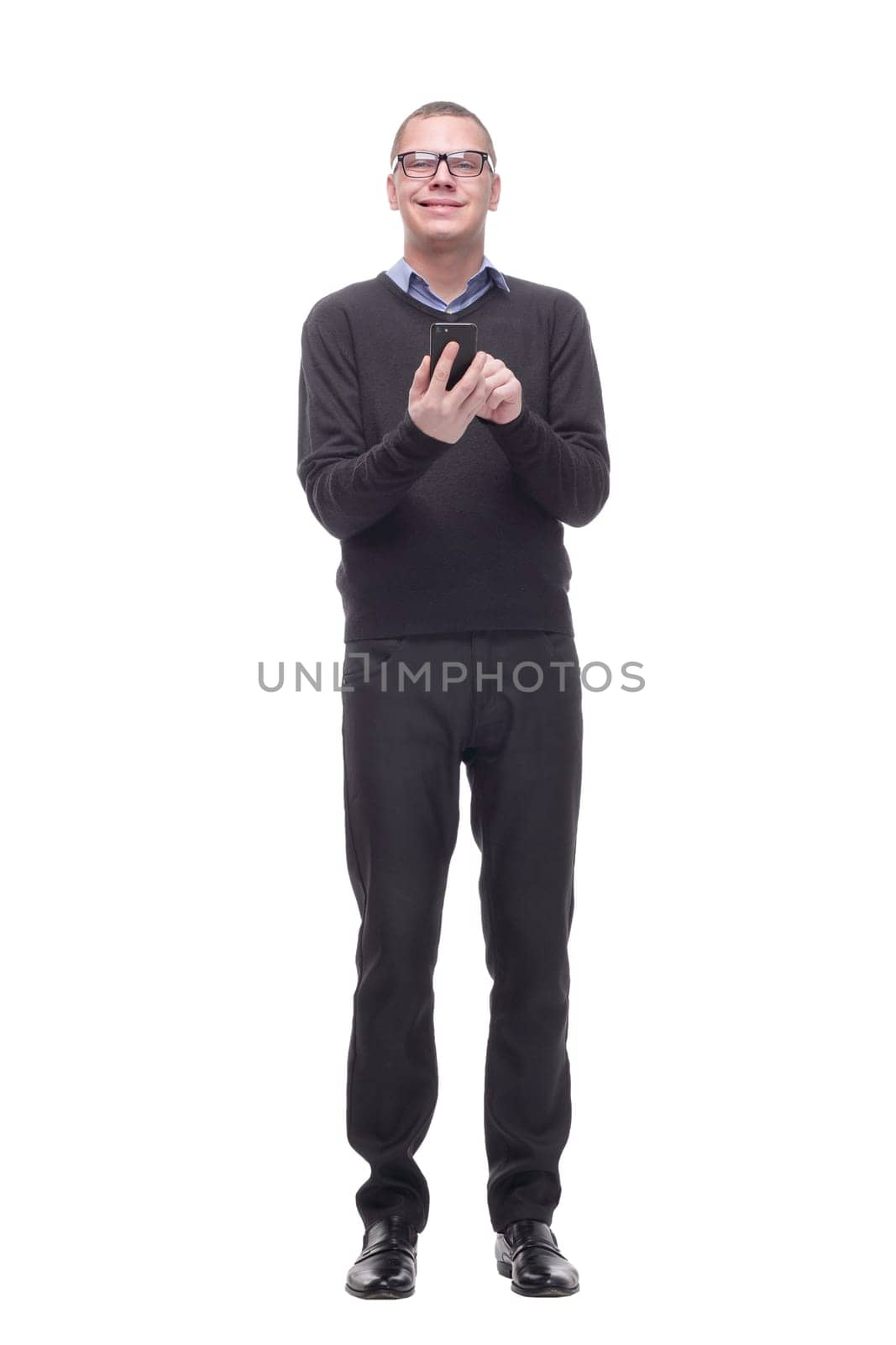 Smiling young man looking at his smart phone while text messaging isolated on white background